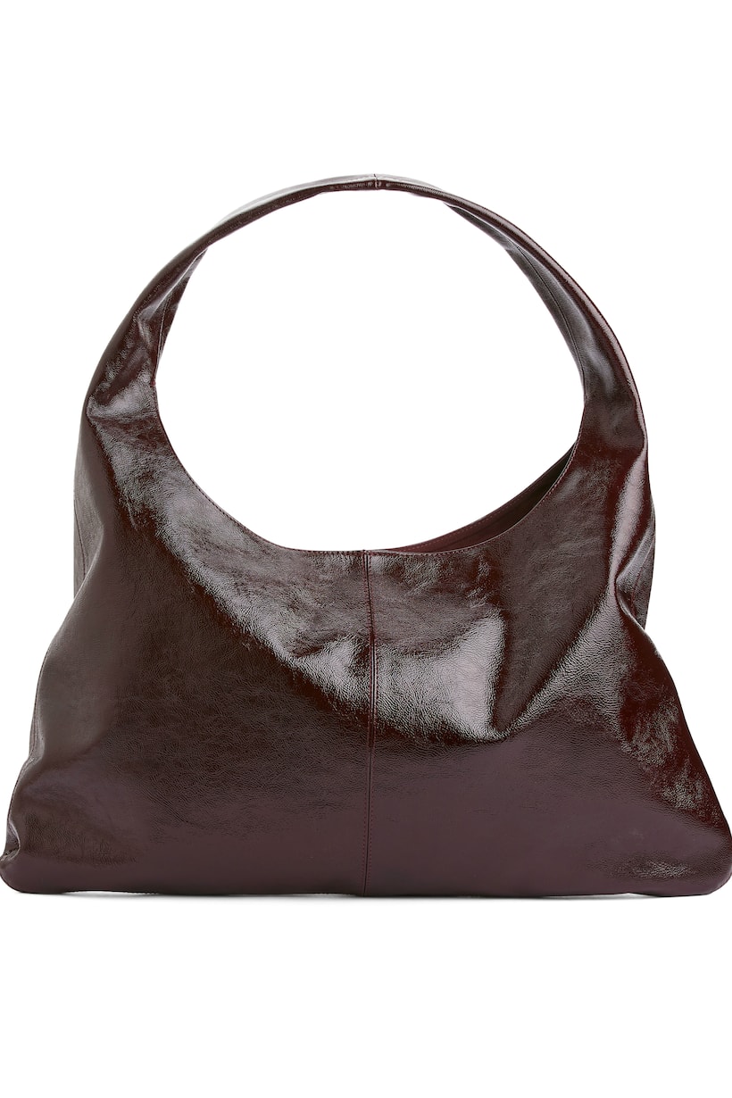 Arket oxblood Leather bag with a shiny finish. A flat style with a slouchy appearance when worn on shoulder. Decorative stitch down the middle. Magnetic closure and inside pocket without zip. Width 54 cm, height 31 cm, drop 17 cm.