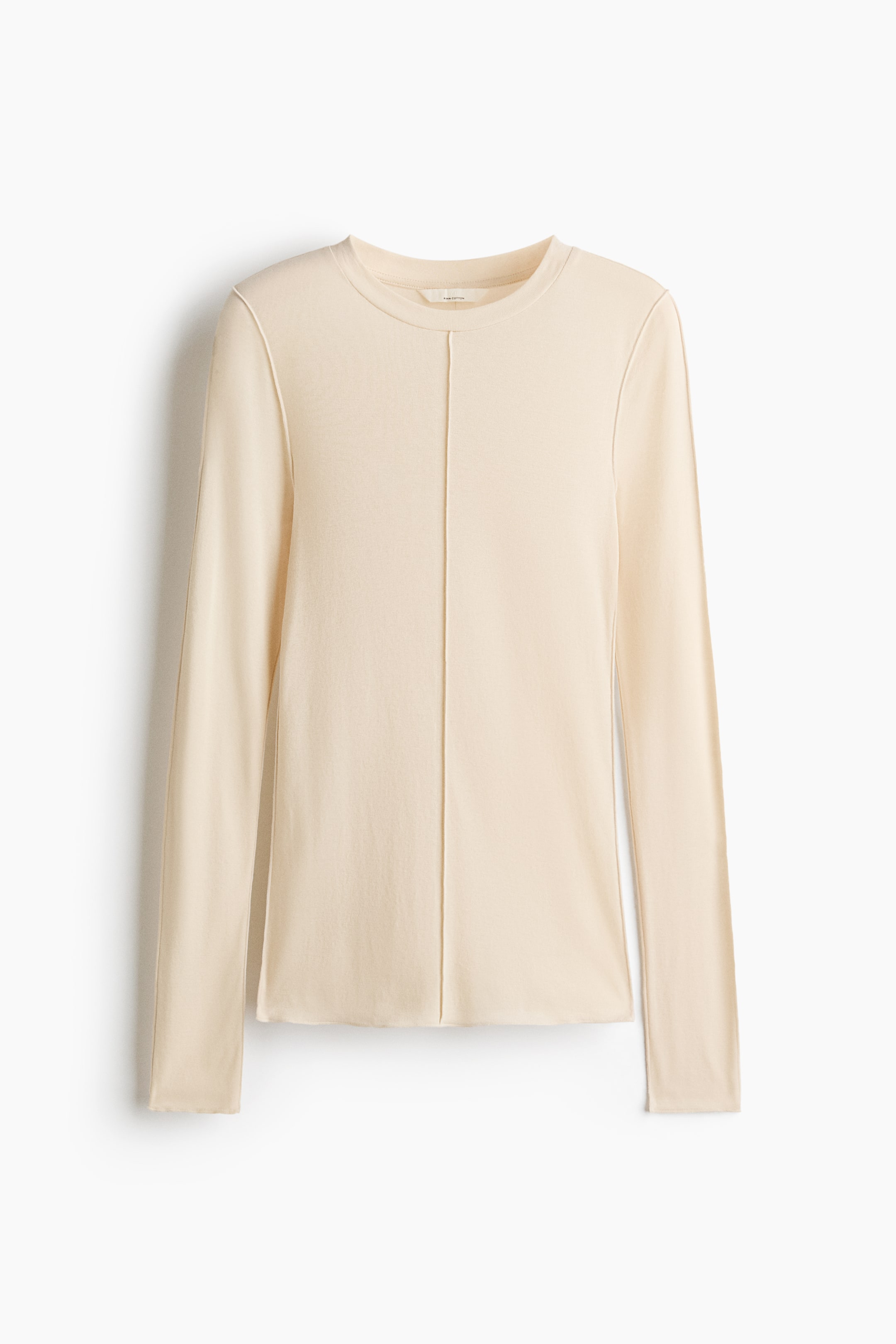 View larger image: A light beige long-sleeved top is shown from the front, featuring a crew neck and prominent topstitched seams running vertically down the centre front and along the shoulders and sleeves.