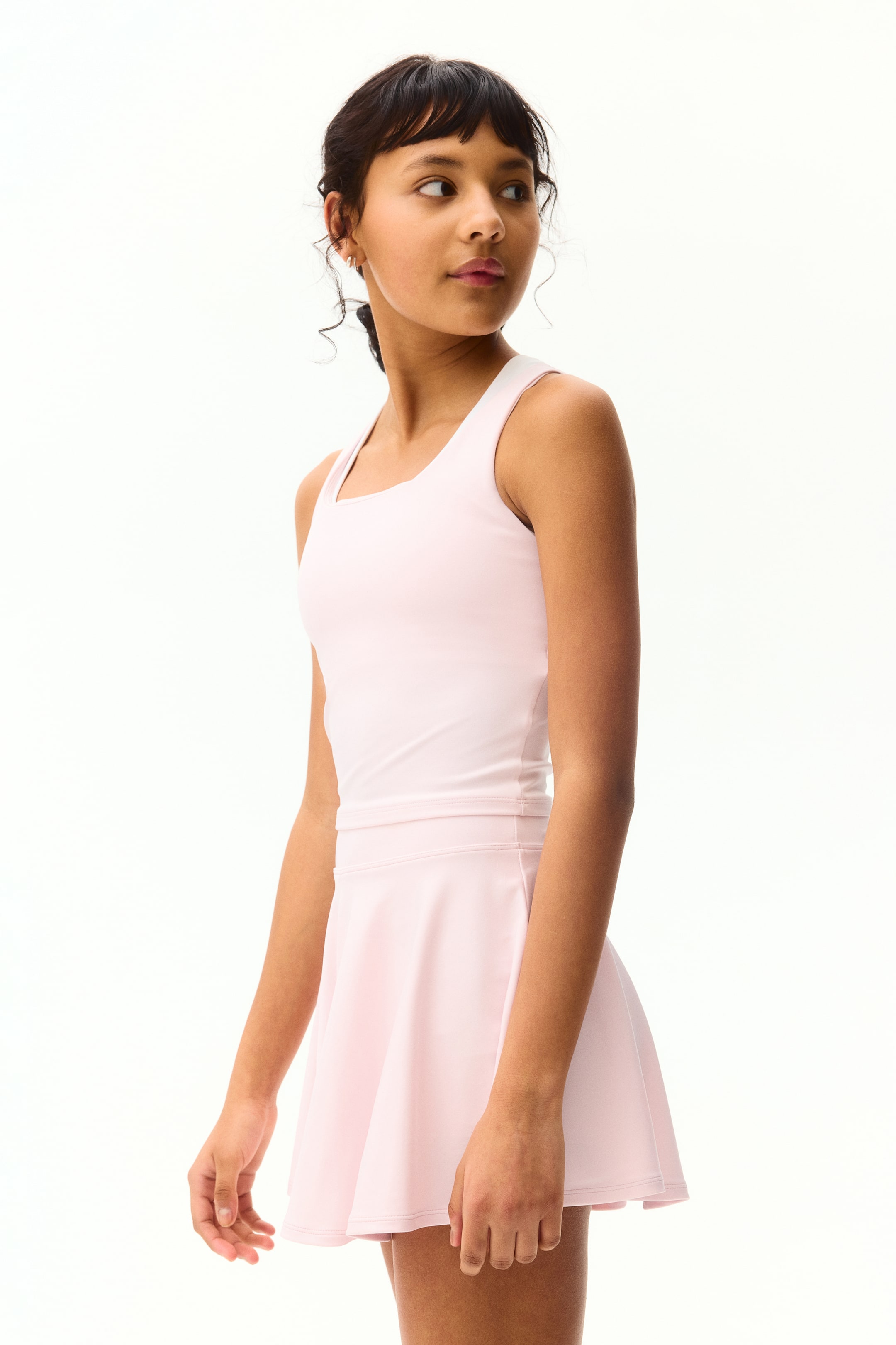 View larger image: The 2-piece light pink sports set with DryMove? features a fitted tank top with a square neckline and wide shoulder straps, showcased from a front-right angle. The coordinating flared skirt sits at the waist, offering a short length.