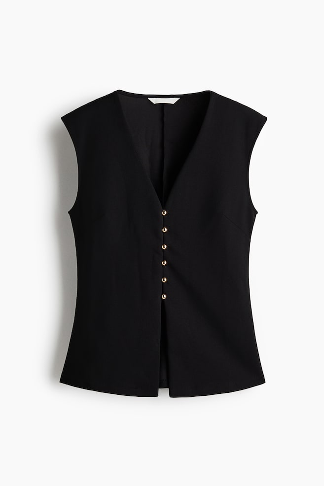 A black tailored sleeveless vest is facing front, featuring a deep V-neckline and slightly extended shoulders. The vest is displaying a front closure with six small gold-tone dome buttons and a clean central split at the bottom hem. - 1