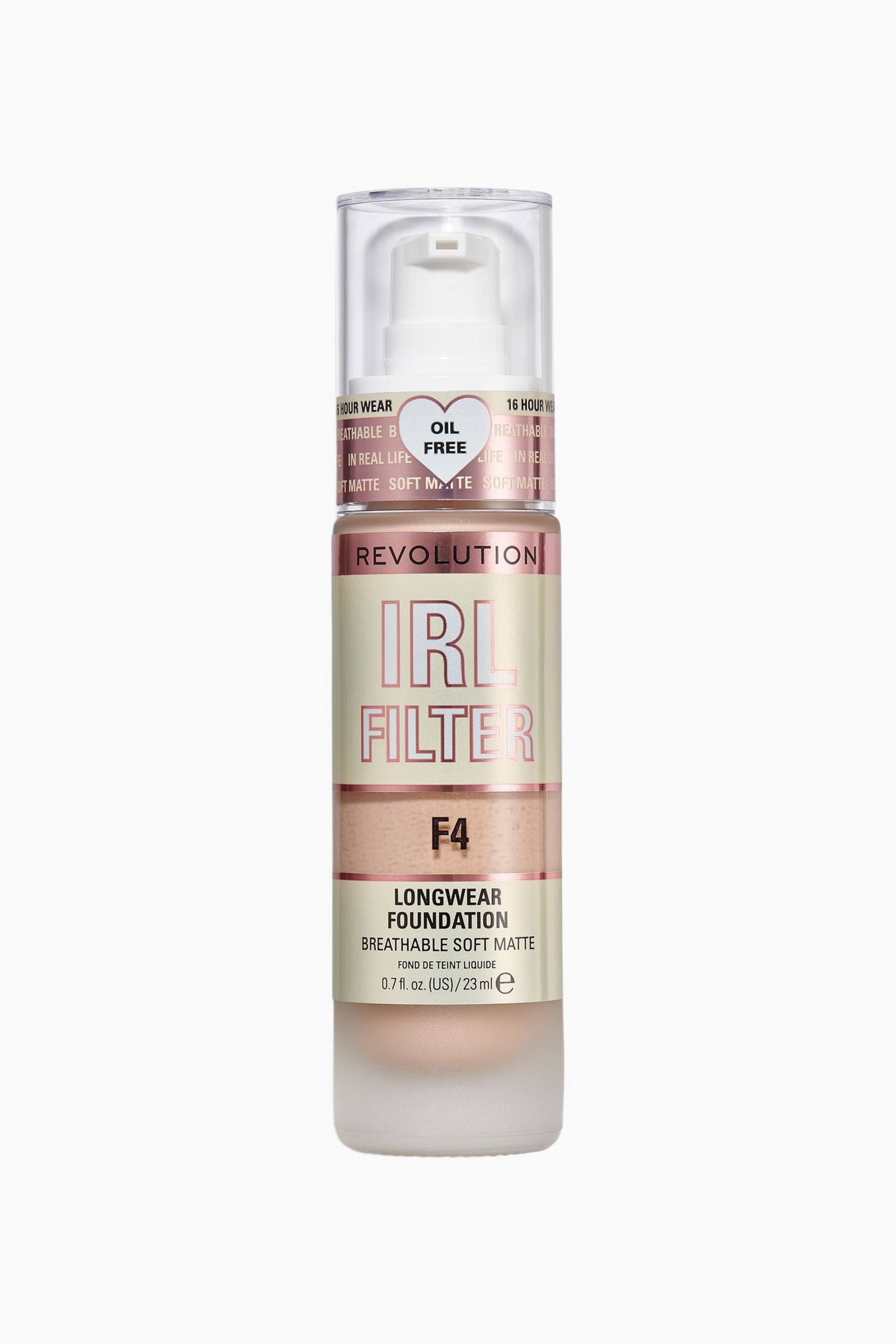 Größeres Bild ansehen: Die Revolution IRL Filter Longwear Foundation steht aufrecht und nach vorne gerichtet und präsentiert ihre zylindrische, mattierte Flasche mit einer hellbeigen flüssigen Foundation. Sie verfügt über eine transparente Kappe über einem weißen Pumpspender, einen roségoldenen Metallring mit einem „OIL FREE“-Aufkleber in Herzform sowie ein cremefarbenes Etikett mit Marken- und Produktdetails, einschließlich des Farbtons „F4“ in Schwarz.