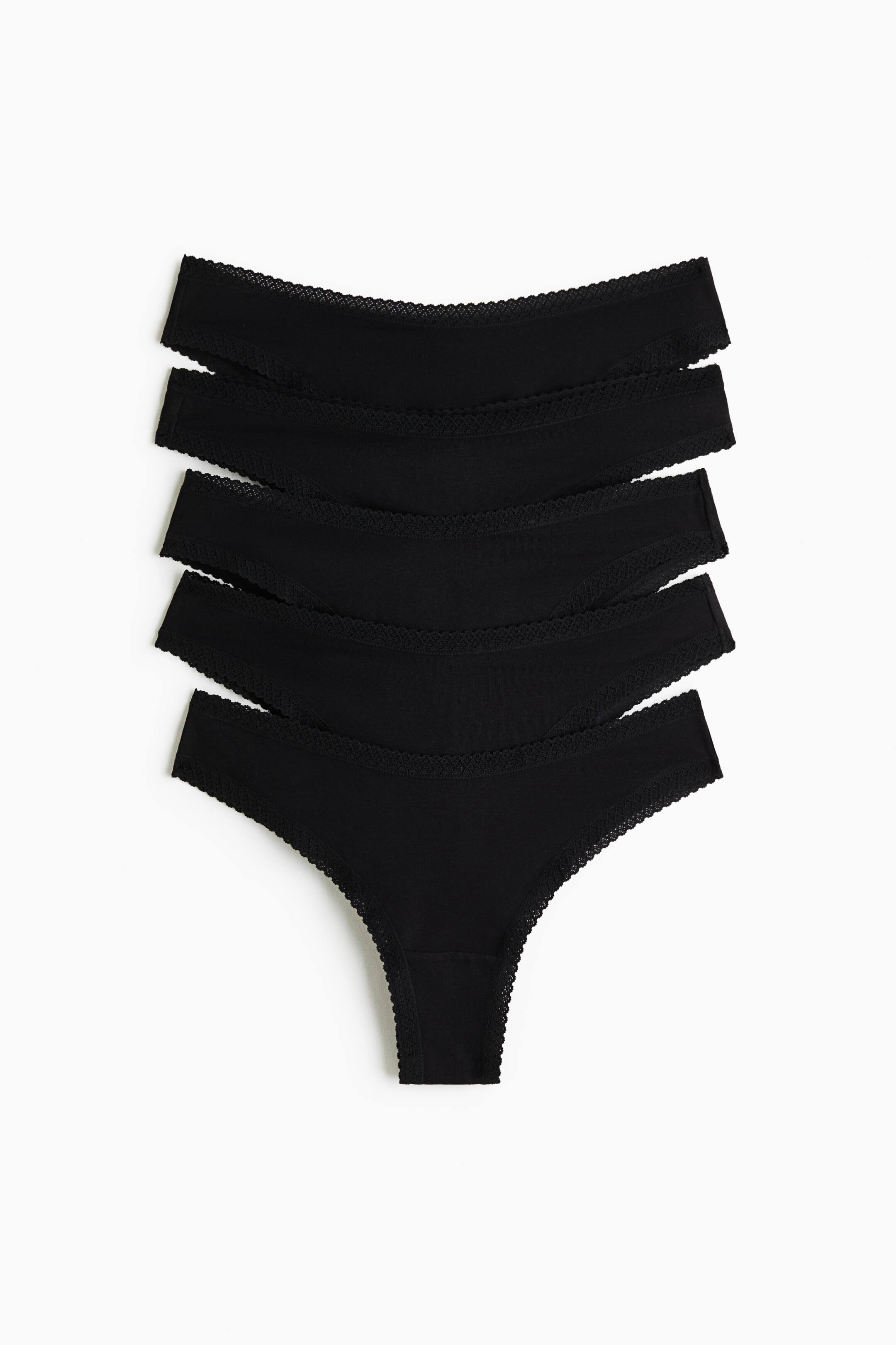 View larger image: A pack of five black thong underwear is laid flat in a vertically stacked, overlapping arrangement facing forward. Each pair features a delicate scalloped lace trim along the waistband and leg openings.