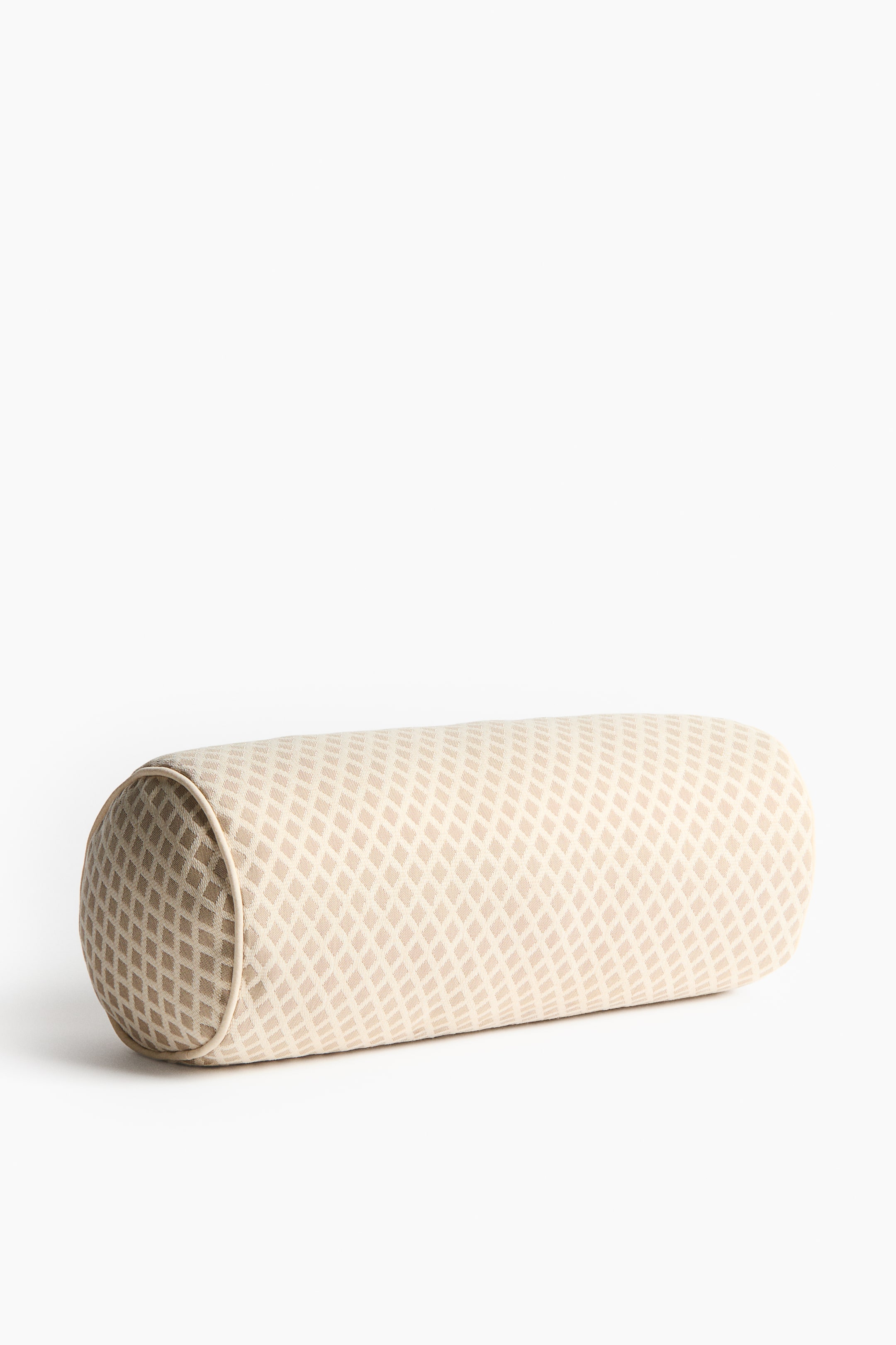 View larger image: A bolster is presenting front, featuring a cylindrical shape. It is covered in a light beige fabric with a textured, jacquard-woven diamond pattern and is detailed with piping along its circular ends.