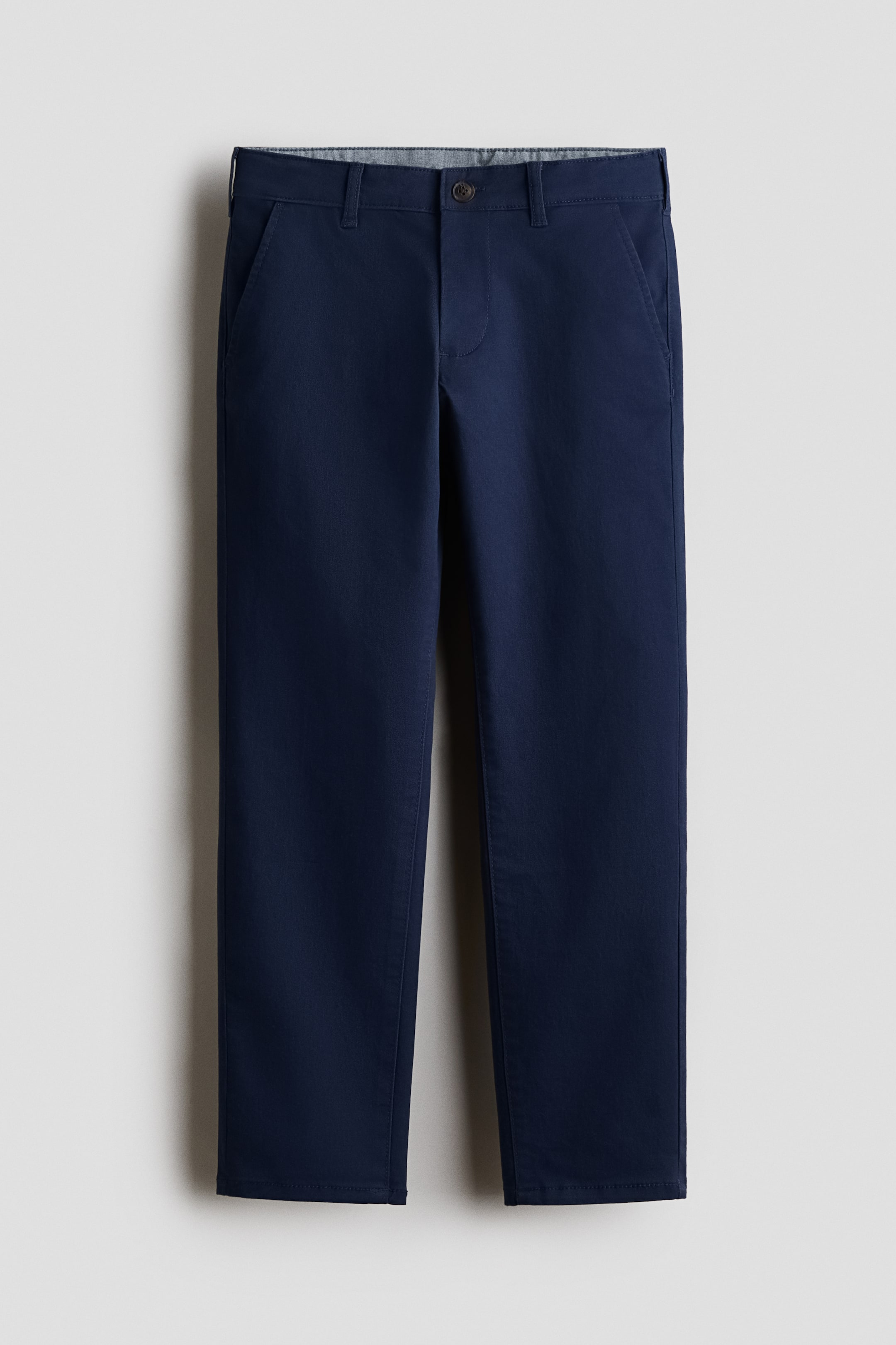 View larger image: Navy blue trousers are showcased in a front view, highlighting a button and zip fastening at the waist. They reveal an inner patterned waistband lining, slanted front pockets, and a straight-leg silhouette with neatly hemmed cuffs.