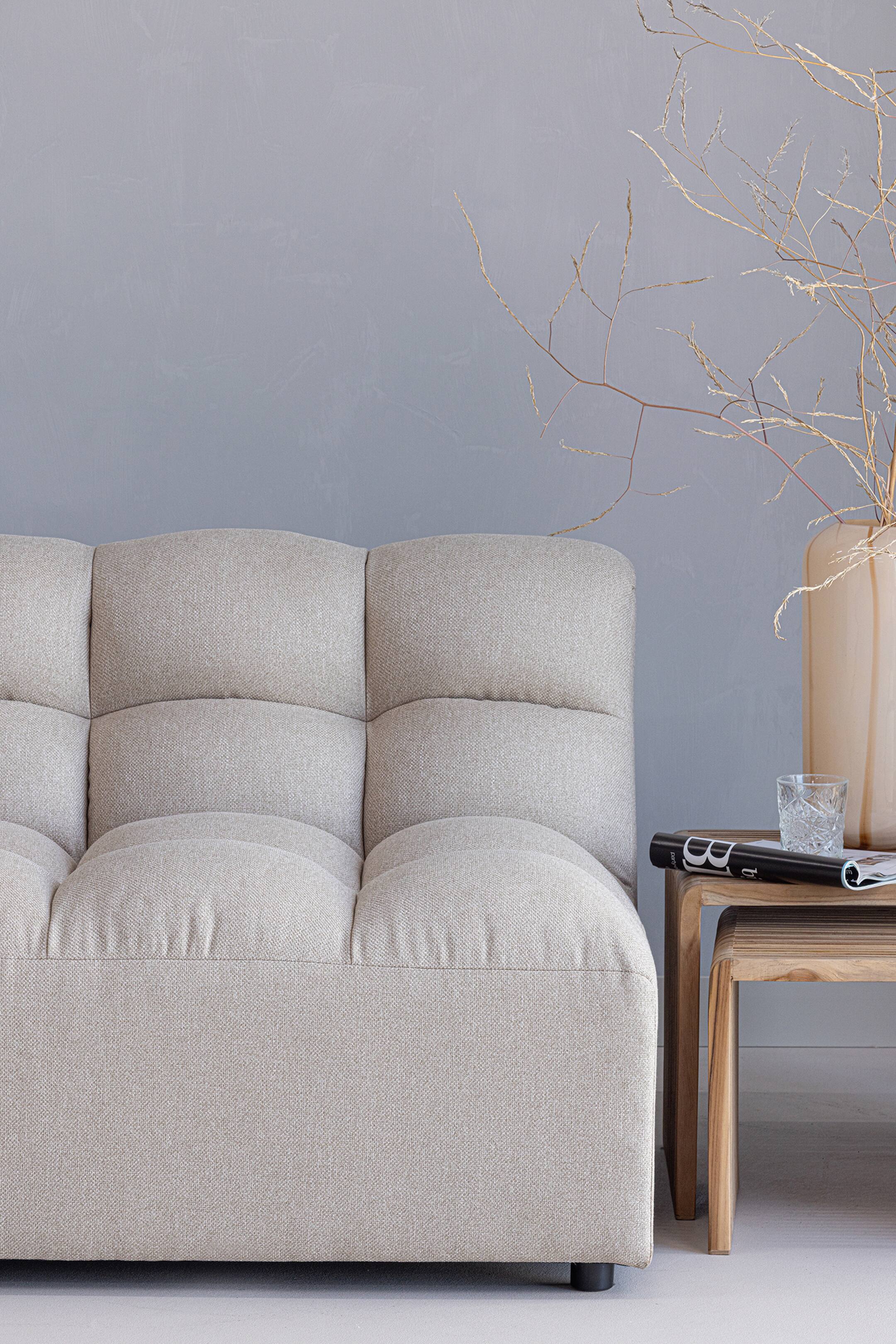 Größeres Bild ansehen: Ein hellbeiges Sofa präsentiert seine Vorder- und rechte Seite und zeichnet sich durch eine tief gesteppten Rückenlehne und Sitzkissen mit klaren Segmenten aus. Das Sofa ist mit einem strukturierten Stoff bezogen und steht auf kleinen dunklen Füßen.