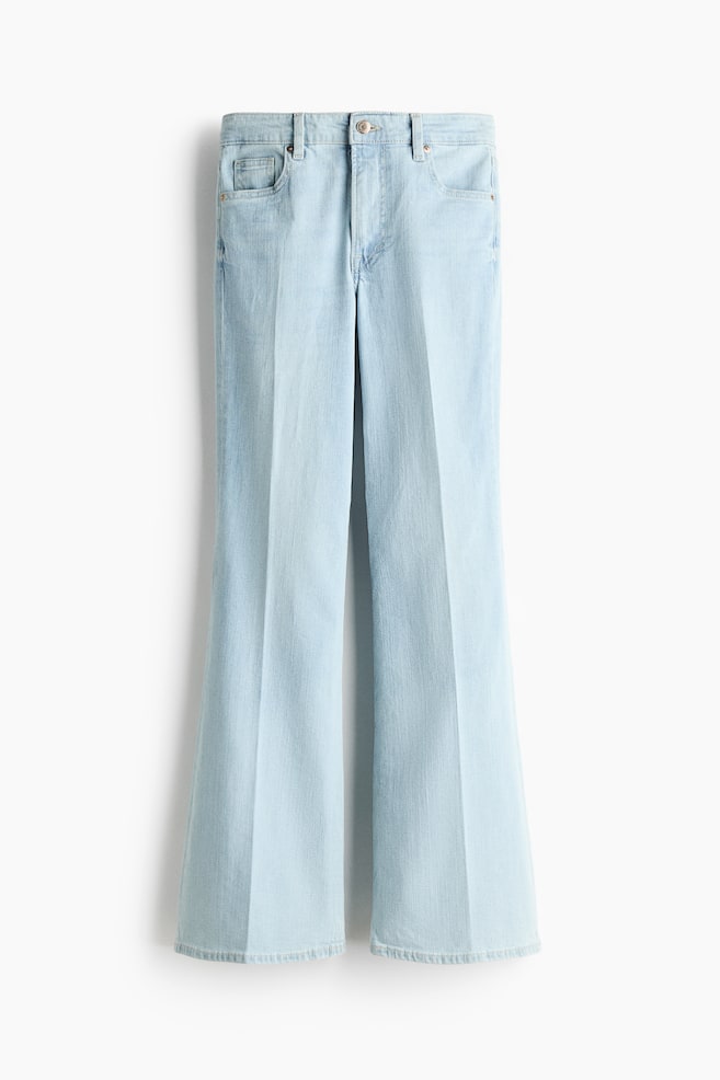 Een lichtblauwe 5-pocket denim jeans wordt van voren getoond. De jeans heeft een zichtbare knoop- en ritssluiting, een slim fit in taille en dij, en een flared snit van de knie tot aan de zoom die doorloopt naar een langere lengte. - 1