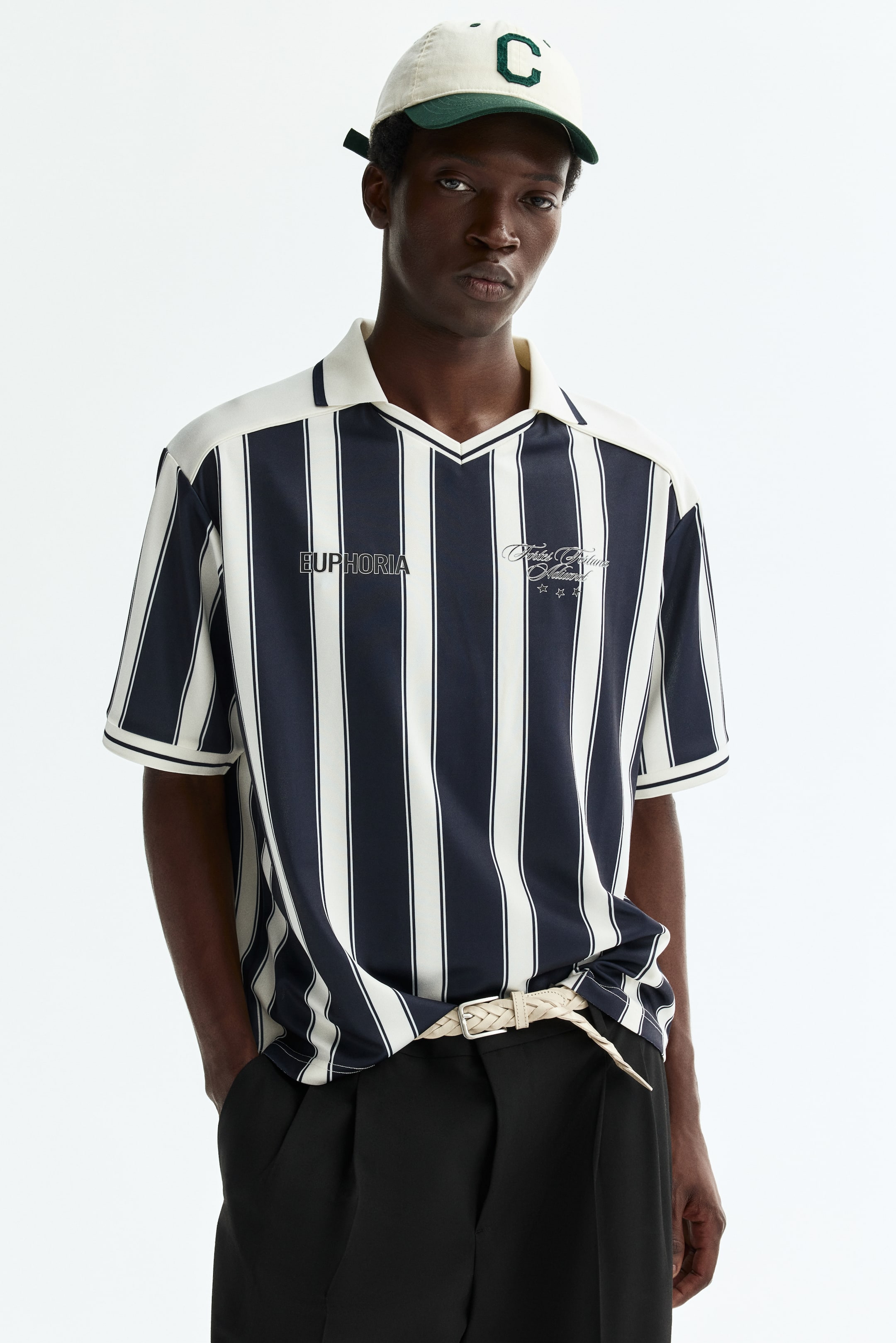 Voir une image plus grande: Une chemise à manches courtes présente des rayures verticales bleu marine et blanc cassé, vue de face. Elle est conçue avec un col pointu blanc cassé, une ouverture en V et des manches courtes affichant des poignets blanc cassé avec une fine rayure marine. "EUPHORIA" est imprimé sur la poitrine gauche et un script stylisé avec deux étoiles sur la poitrine droite.