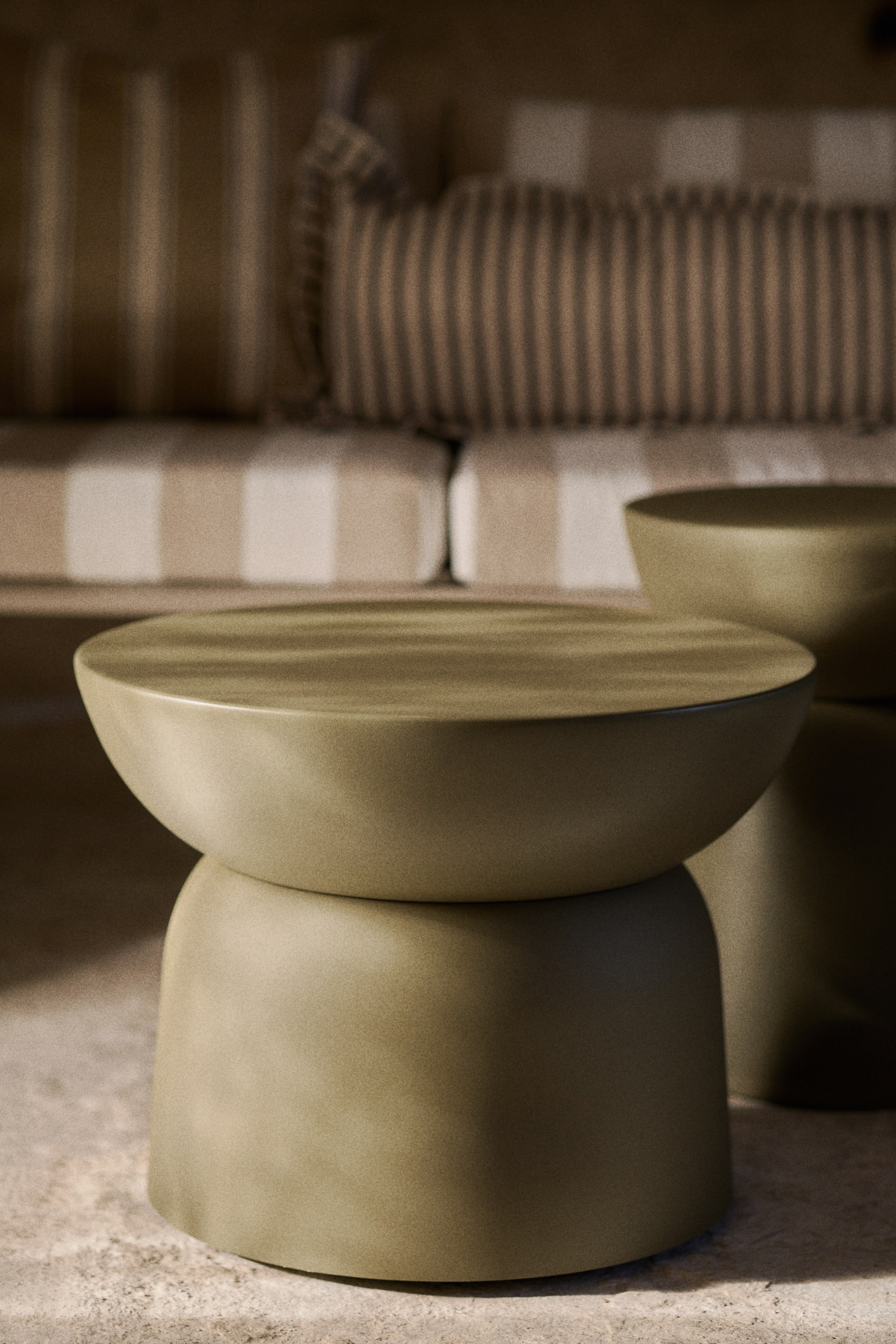 View larger image: The coffee table is showcased from the front, boasting an olive green, subtly textured metal surface. It's crafted with one dome shape seated atop another, creating a streamlined silhouette with a circular flat top.