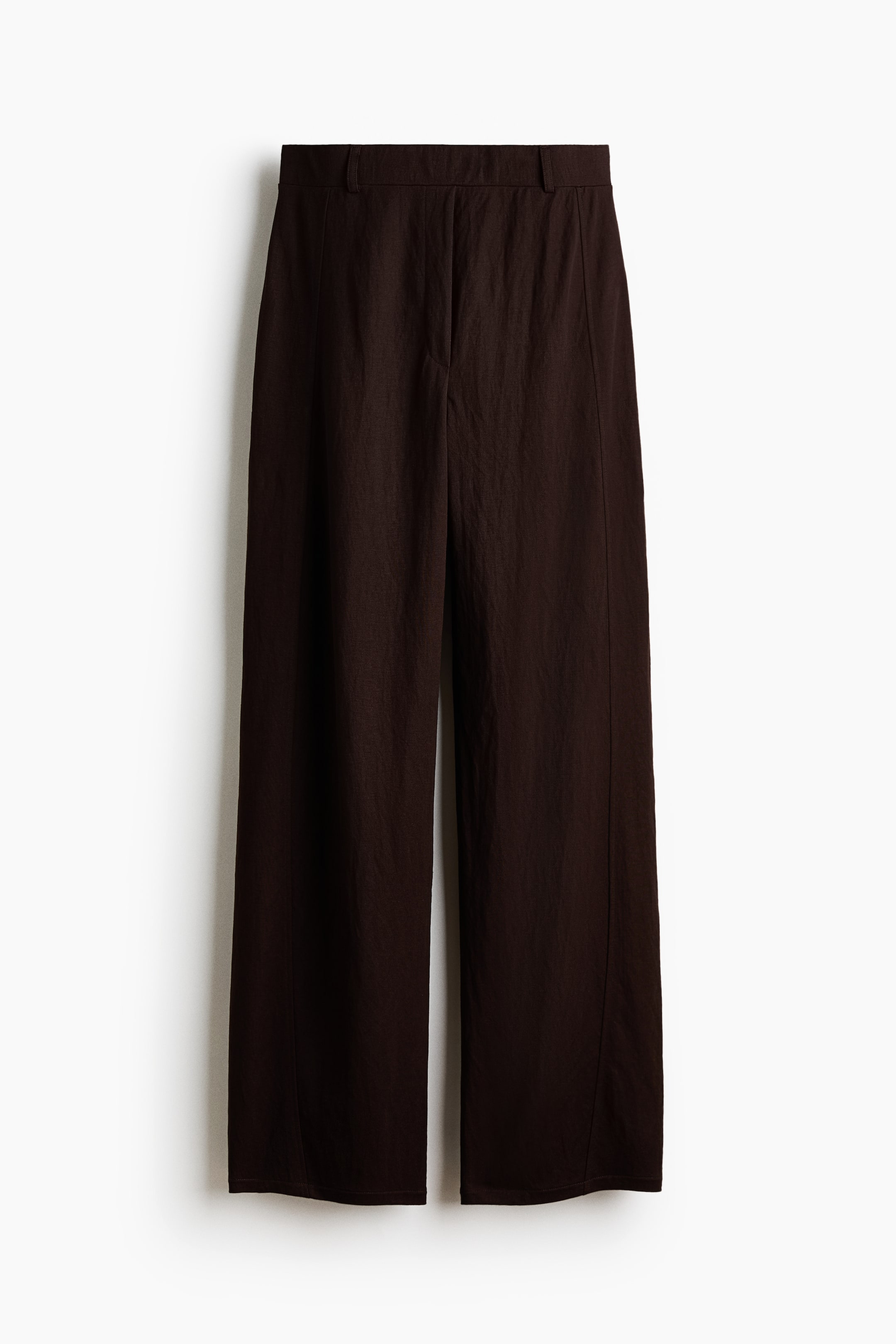 View larger image: A pair of dark brown trousers is displayed from the front, showcasing a flat waistband with belt loops and a concealed fly closure. The wide-leg trousers exhibit a crinkled texture, with vertical seams running down the front of each leg.