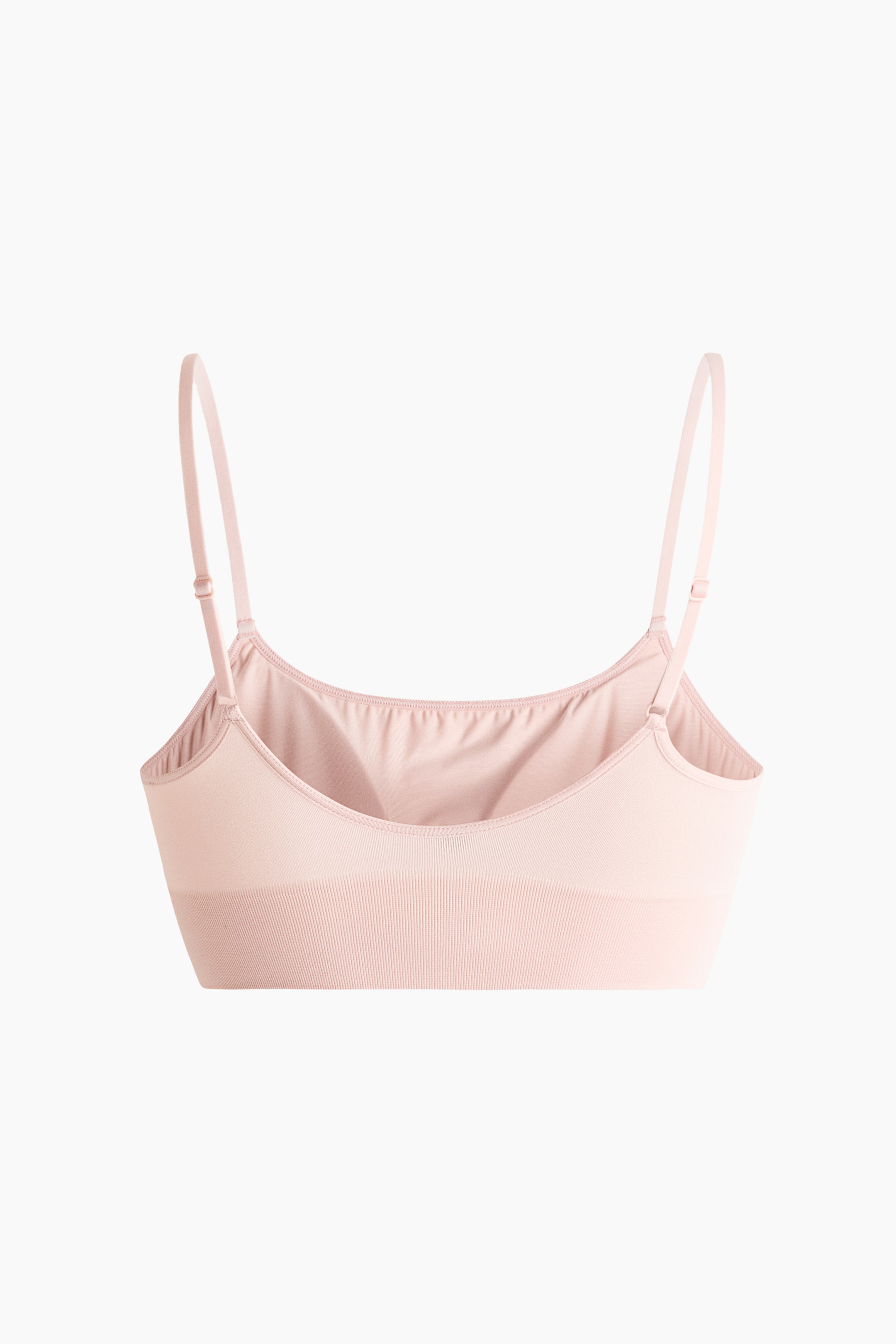 Visualizza l'immagine ingrandita: Un reggiseno a triangolo rosa chiaro si presenta frontalmente, caratterizzato da un design liscio e senza cuciture, con spalline sottili regolabili e coppe foderate. Presenta un ampio orlo a coste ed è visibilmente privo di chiusure.