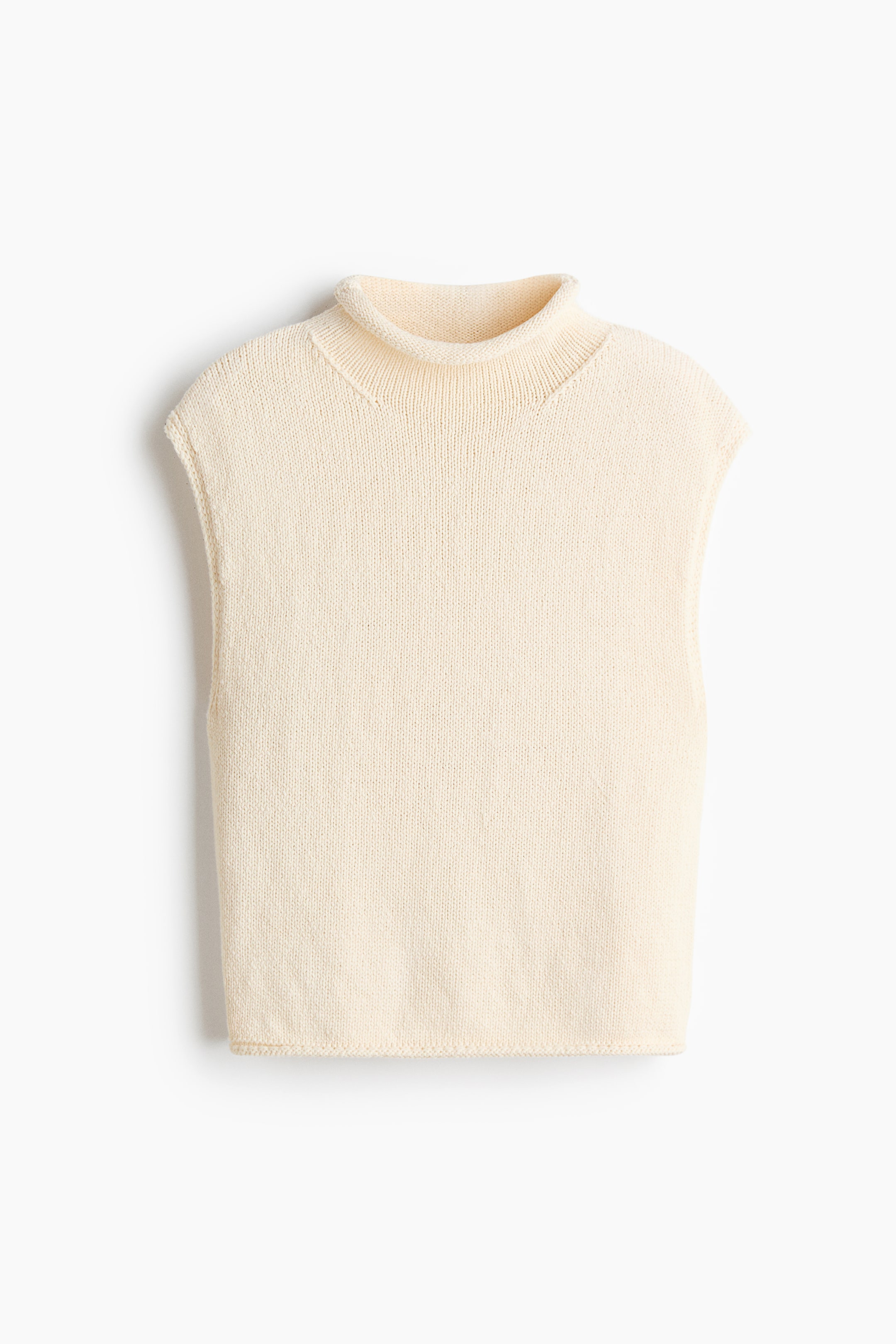 Ampliar la imagen: Un suéter sin mangas en color blanco hueso presenta un cuello alto doblado y sisas terminadas, mostrando su tejido liso de punto jersey.