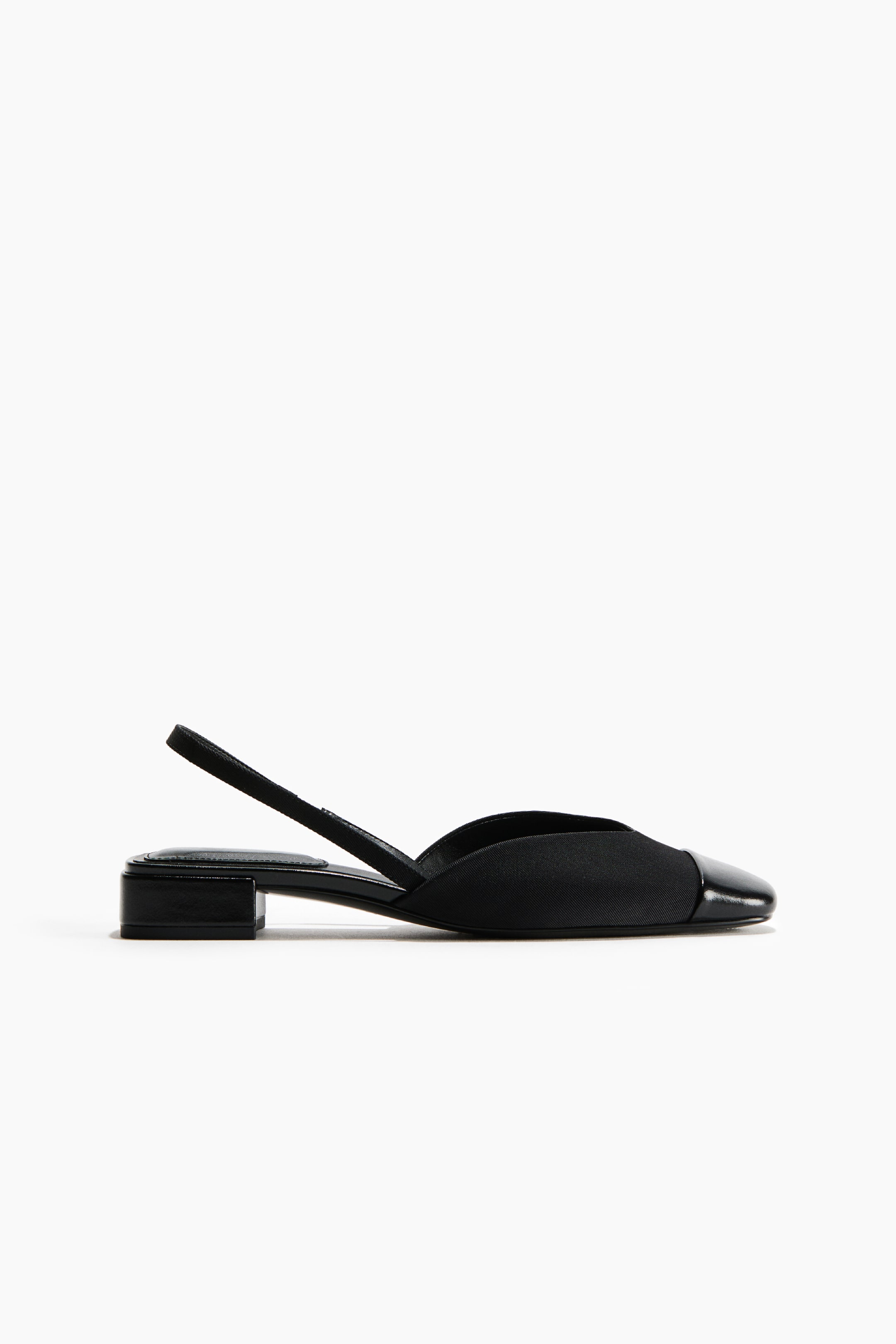 Agrandir l'image: Une chaussure slingback noire est présentée en vue de profil, avec une tige en tissu mat, un bout contrastant en cuir verni brillant et un petit talon bloc rectangulaire.