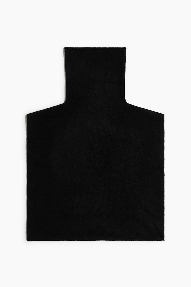 A black knit turtleneck collar is displaying from the front, featuring a high, tubular neck that is extending into a flat, rectangular bib panel. - 1