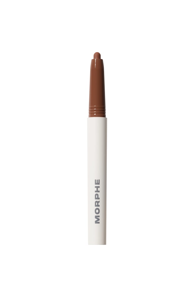 Sculptwear Signature Lip Pencil står lodret og har en hvid cylindrisk skaft med brandnavnet "MORPHE" trykt lodret i grå versaler. Toppen af blyanten viser en blank, varm brun plastikhals og en blotlagt, afrundet brun kridttip. - 1