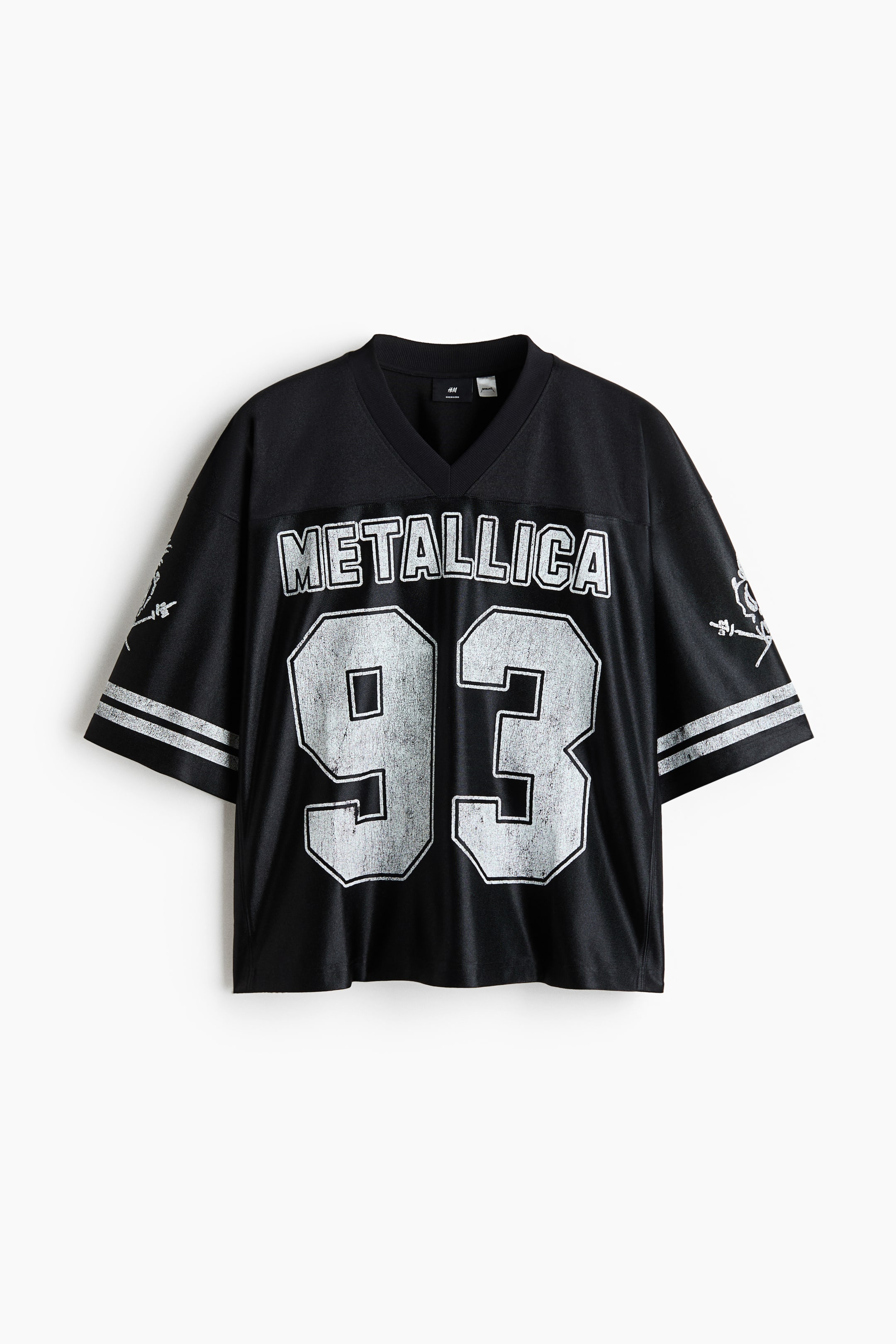 Ver imagen más grande: Una camiseta de jersey negra se presenta en vista frontal, con un cuello en V y mangas cortas con dos rayas blancas en la izquierda. En la parte delantera se muestra el texto "METALLICA" sobre los grandes números "93" desgastados, ambos en blanco con un contorno negro.