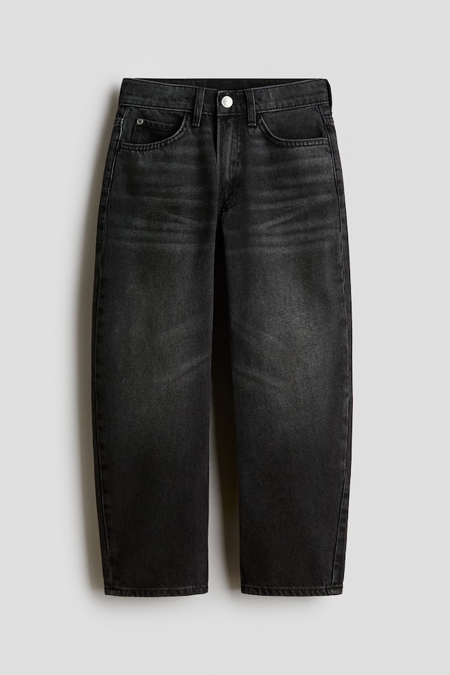 Eine Paar verwaschene schwarze Denim-Jeans ist von vorne zu sehen und verfÃ¼gt Ã¼ber einen lockeren, gerade geschnittenen Beinverlauf. Die Jeans zeigt ein klassisches Five-Pocket-Design, GÃ¼rtelschlaufen, einen einzelnen silbernen Knopfverschluss und dezente Used-Waschungen im Bereich der oberen Oberschenkel. - 1