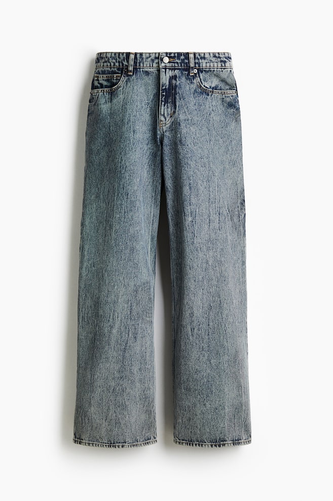 Loose-fit-Jeans werden von vorne präsentiert und zeigen eine niedrige Taille, einen tiefen Schritt und gerade Beine. Sie sind aus festem Baumwoll-Denim gefertigt, mit einer ausgewaschenen blauen Waschung, 5-Pocket-Styling und einem Reißverschluss mit Knopfverschluss. - 1