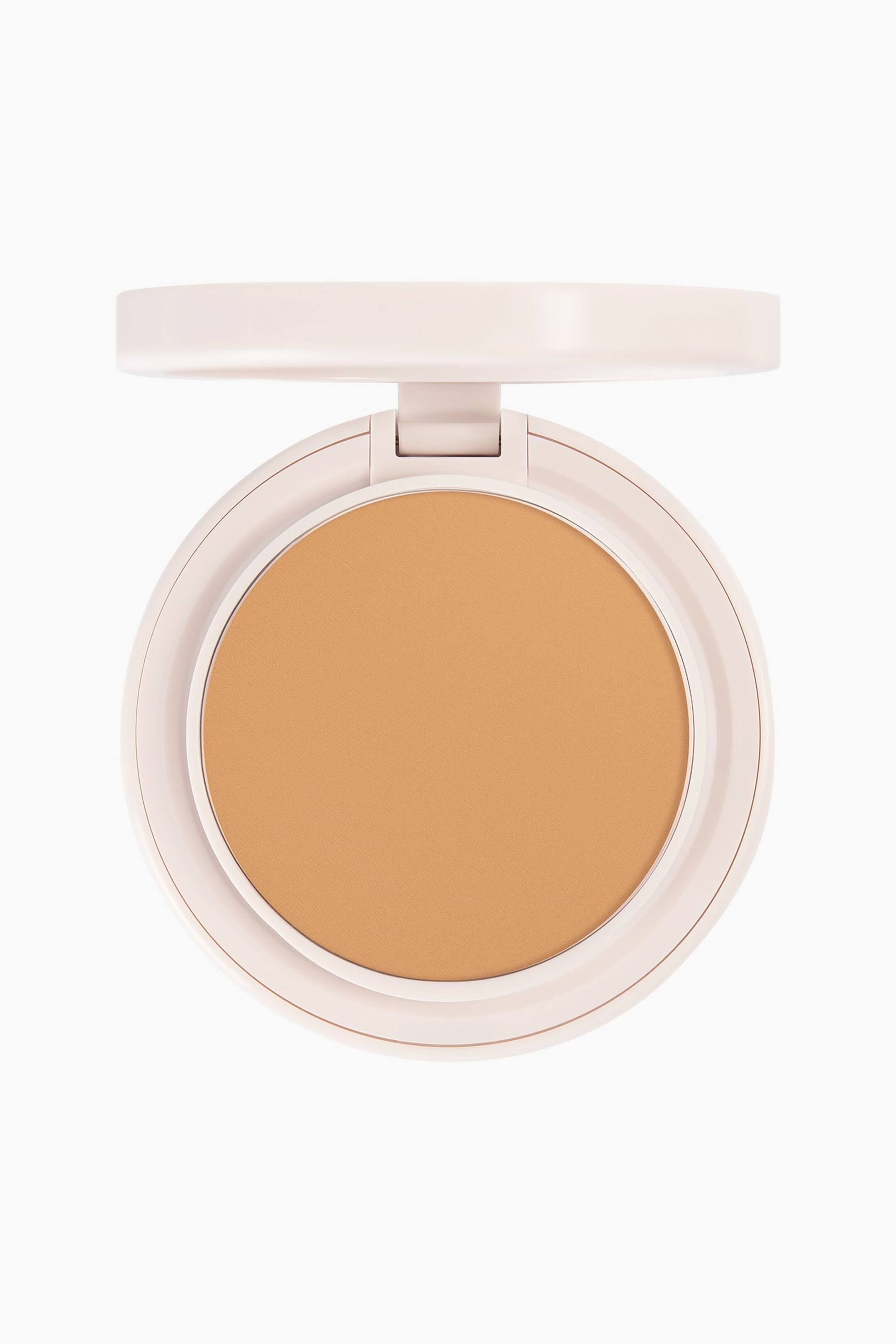 Se større billede: Natural Blur Powder Foundation fremstår i et åbent, cirkulært kompakt etui i en lys beige nuance set direkte forfra. Et glat, varmt tonet, medium-tan presset pudder ligger i den runde pudderpande, mens låget står åbent øverst.
