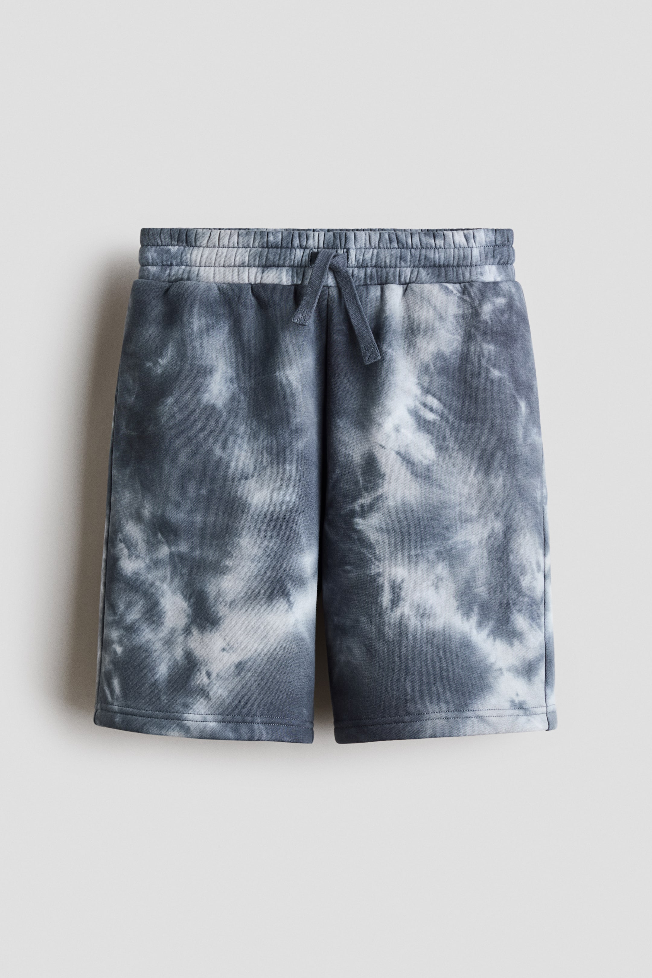 View larger image: The shorts showcase a grey and white tie-dye pattern. They come with an elasticated waistband, highlighted by a visible drawstring at the front, and feature straight hems.