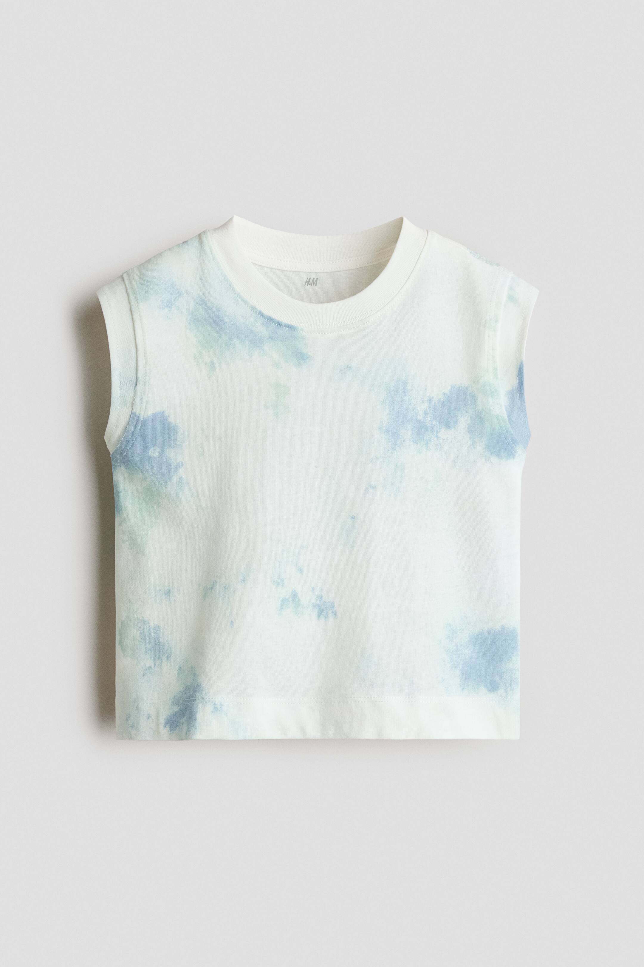 View larger image: A sleeveless T-shirt, shown from the front, features a white base decorated with a soft blue and light green tie-dye pattern. The garment features a ribbed crew neck, wide armholes, and a straight hem.