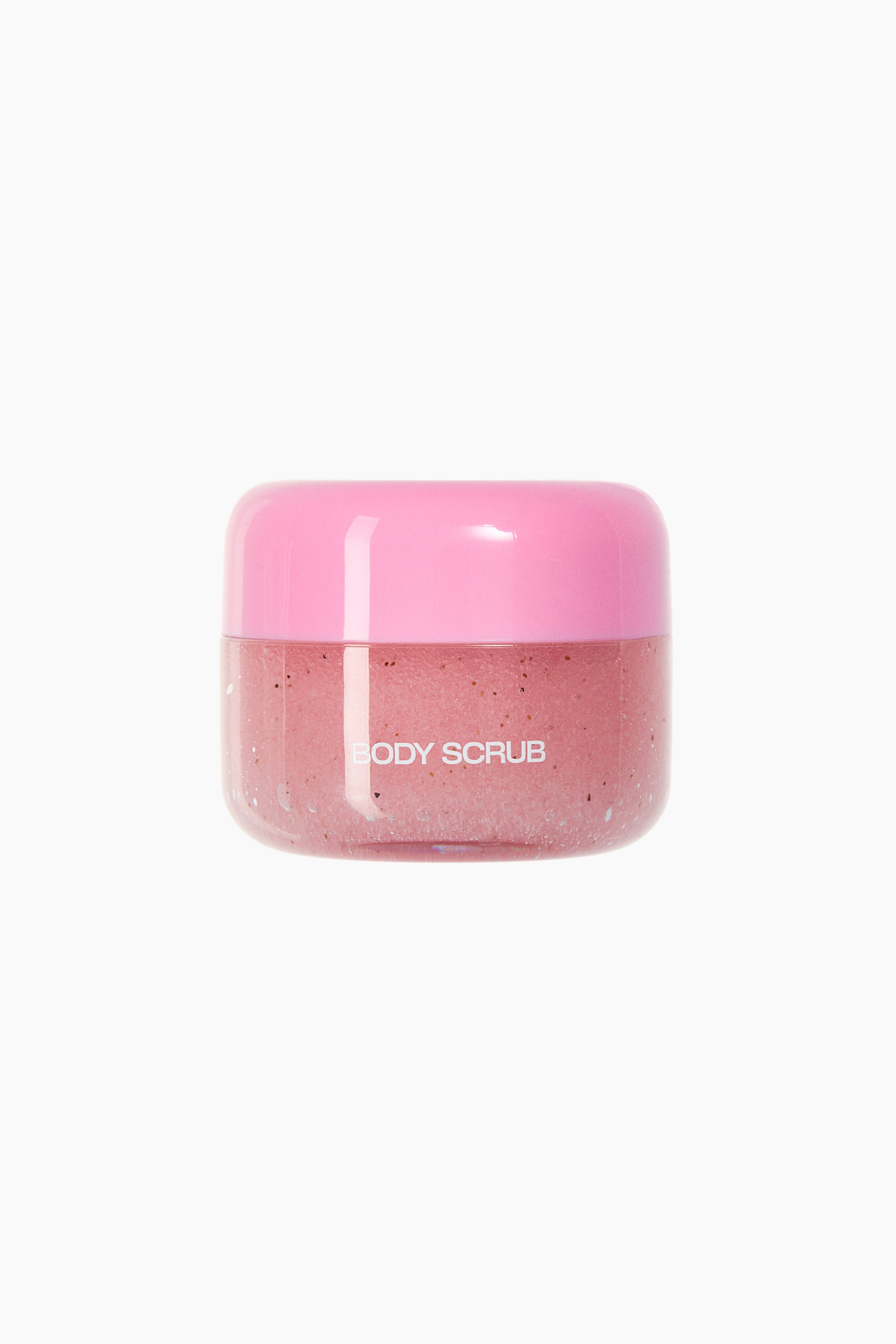 View larger image: Showing a front view, a small, rounded jar displays a pink body scrub with visible dark exfoliating particles through its clear container. The jar features the words "BODY SCRUB" printed in white on the front and is topped with a smooth, dome-shaped pink lid.