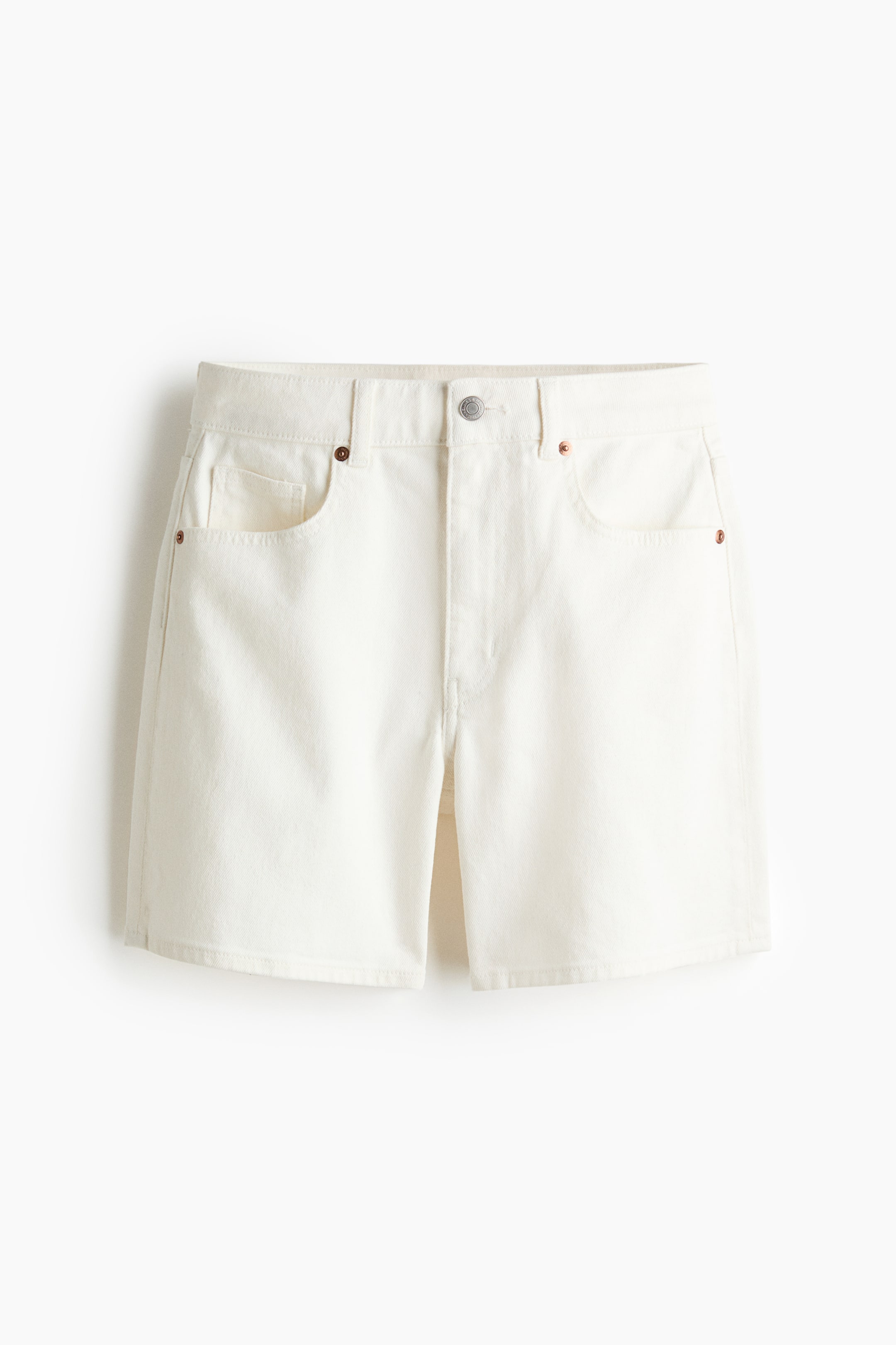 View larger image: Ecru denim shorts are showcased from the front, featuring a button closure, belt loops, and front slash pockets adorned with copper-toned rivets.