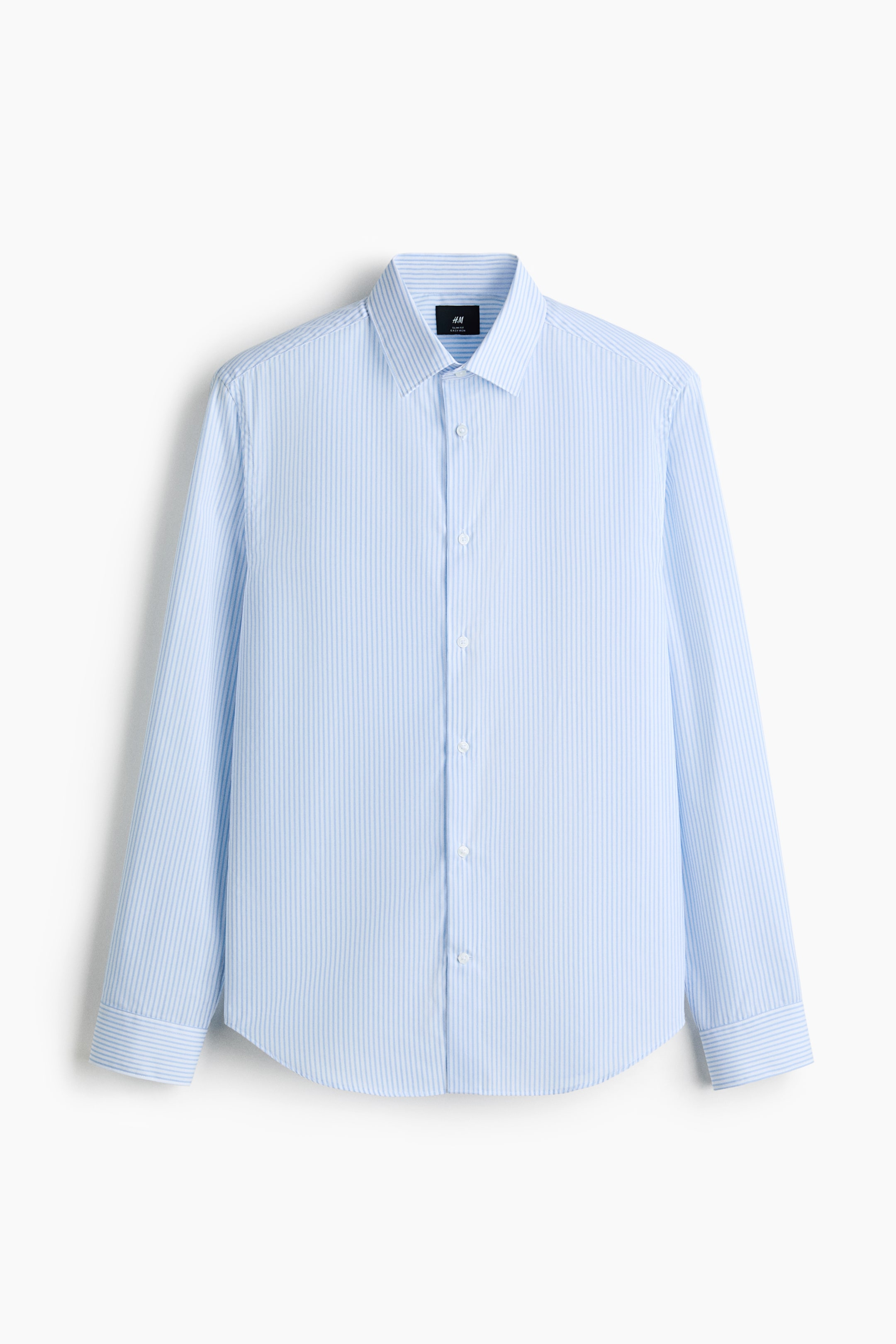 View larger image: A light blue shirt with thin white vertical stripes is hanging front-facing, featuring a turn-down collar and a classic button-front. It is displaying long sleeves with adjustable buttoning at the cuffs, a visible sleeve placket, and a gently rounded hem.