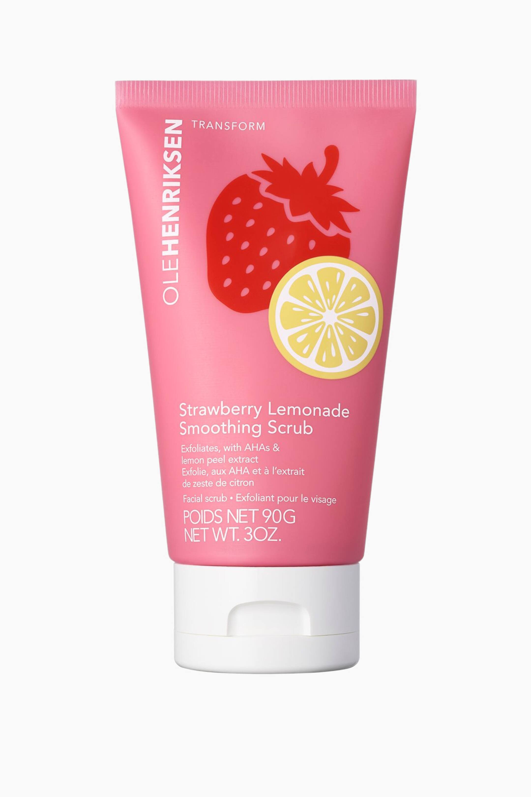 Visa större bild: En rosa tub med klämfunktion av Ole Henriksen Strawberry Lemonade Smoothing Scrub står upprätt och vänd framåt, med ett vitt fliptopplock vid basen. Tuben är tryckt med en stor illustration av ett rött jordgubbsmotiv och en gul citronskiva nedanför, medan svart text visar varumärkesnamnet, produktnamnet och nettovikten.