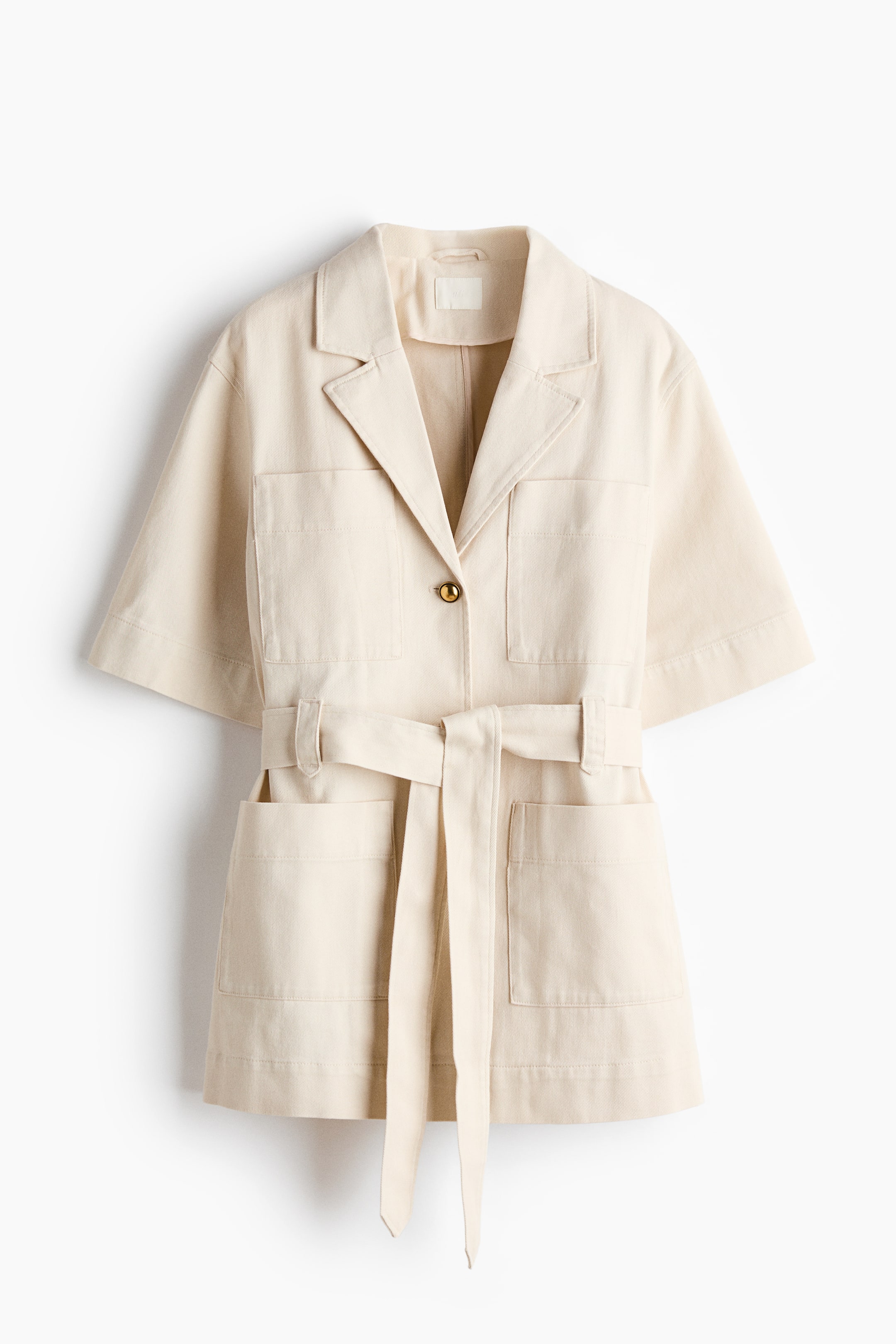View larger image: A light beige short-sleeved jacket is showcased from the front. It features notch lapels, a single gold button closure, and four patch pockets on the front, with a matching tie-waist belt elegantly cinching the waist.