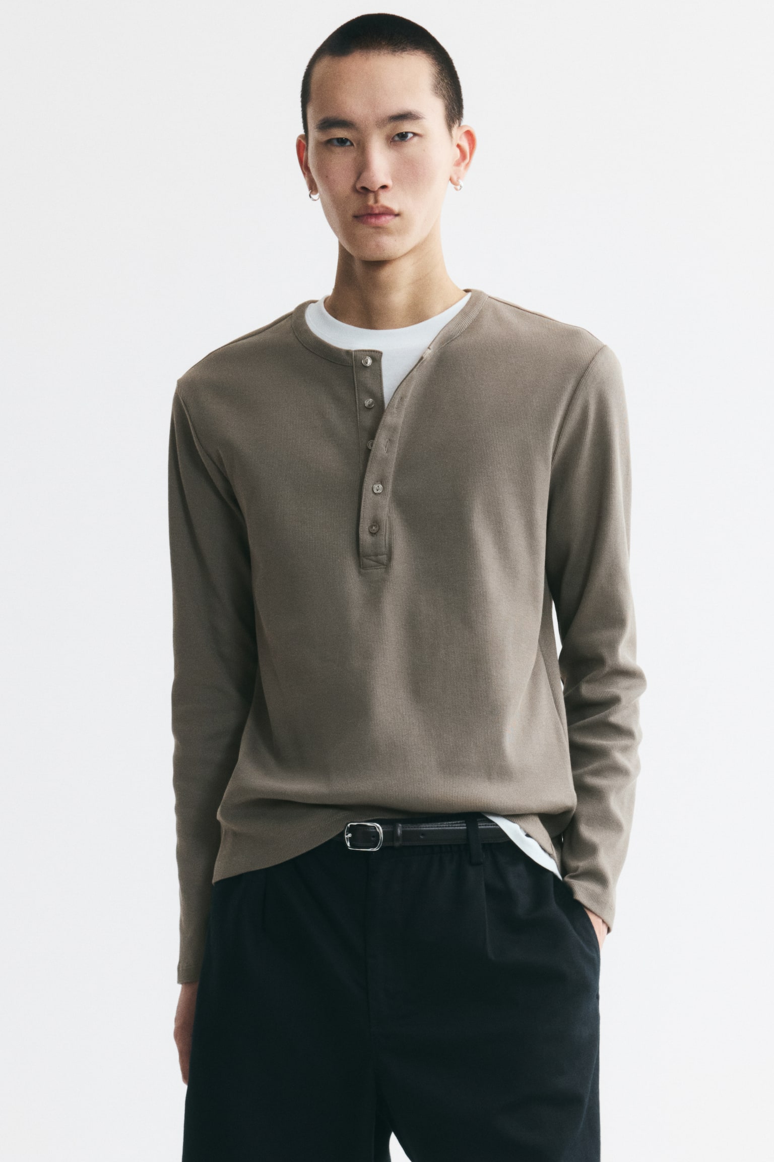 Áo Henley dài tay màu nâu xám đang hướng về phía trước, nổi bật với chất liệu vải cotton jersey gân. Áo có cổ tròn với hàng nút bấm năm cái và dáng ôm gọn gàng. - 1
