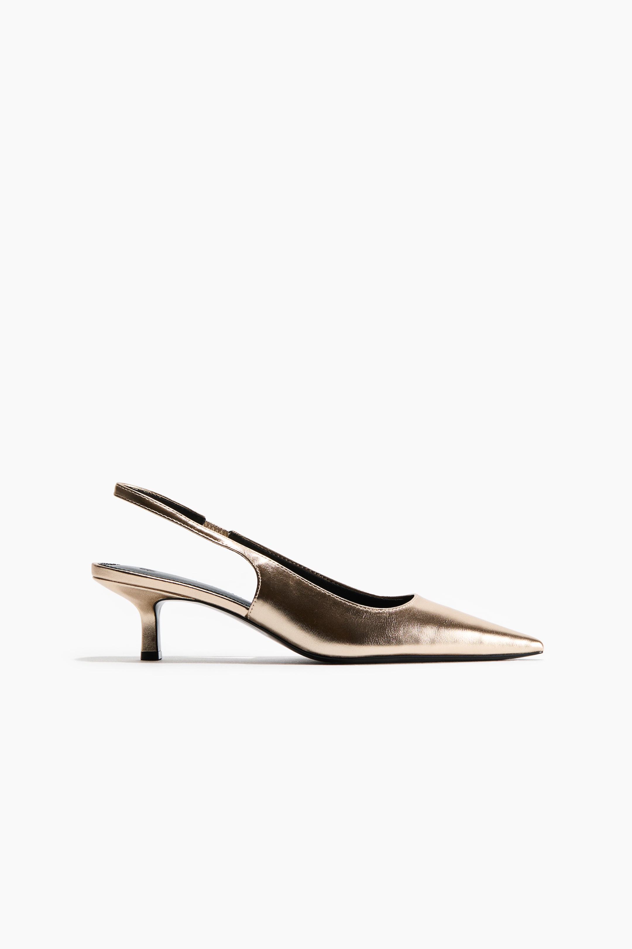 View larger image: A metallic gold slingback shoe is shown in side profile facing right, featuring a pointed toe, a narrow ankle strap with a black elasticated insert, and a low, partially covered kitten heel.