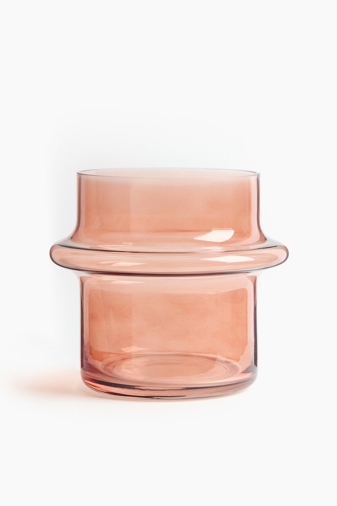 Eine kleine Vase, aus durchscheinendem pink-braunem Glas gefertigt, zeichnet sich durch ein gestuftes Design von vorne aus. Sie präsentiert eine breite zylindrische Öffnung, einen ausgeprägten, gerundeten Mittelteil, der sich nach außen erweitert, und einen zylindrischen Sockel. - 1