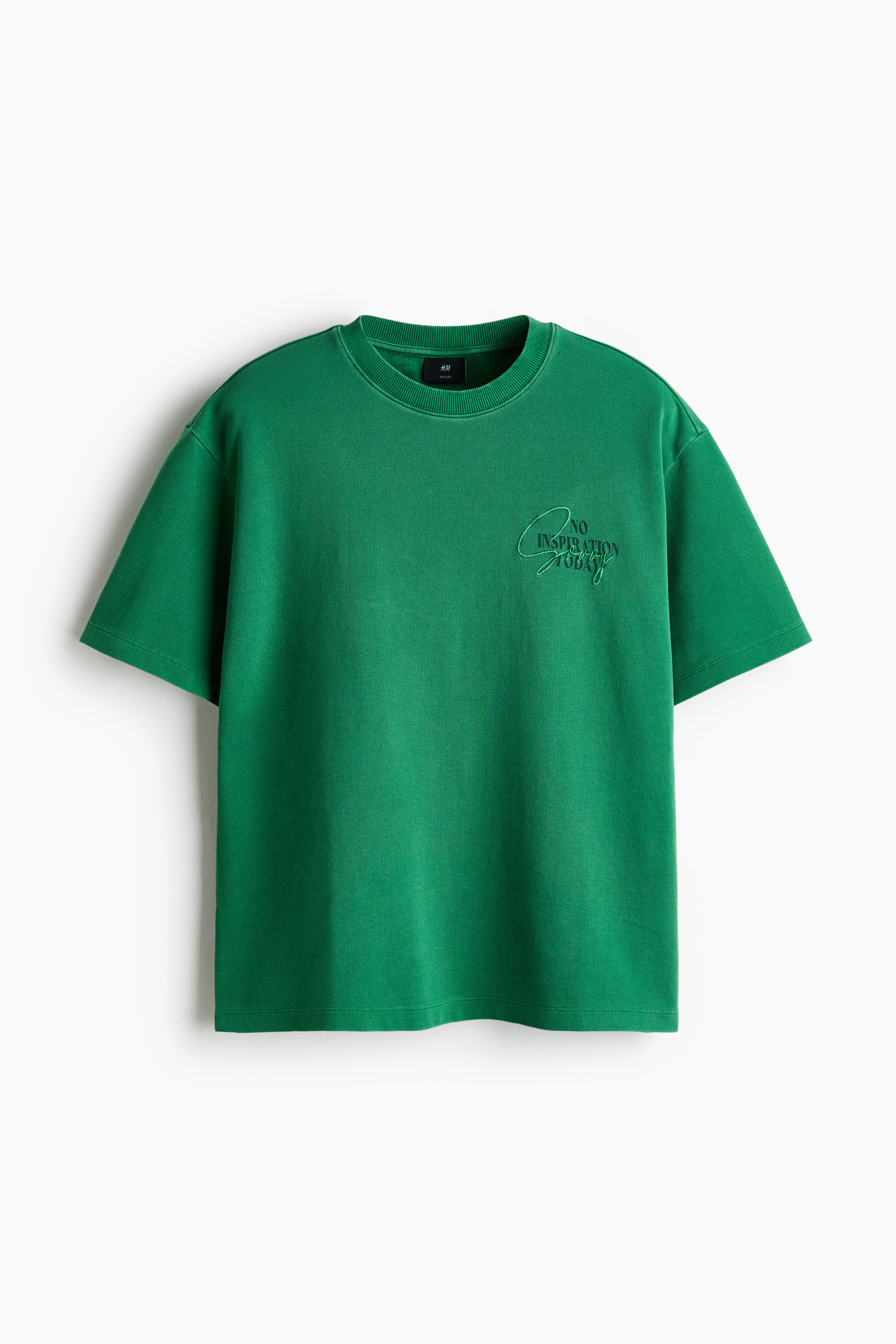 View larger image: A green t-shirt is displayed from the front in a relaxed fit, showcasing a round, ribbed neckline. It features a subtle, tone-on-tone design with the words 'NO INSPIRATION TODAY' across the front chest, and concludes with a straight-cut hem.