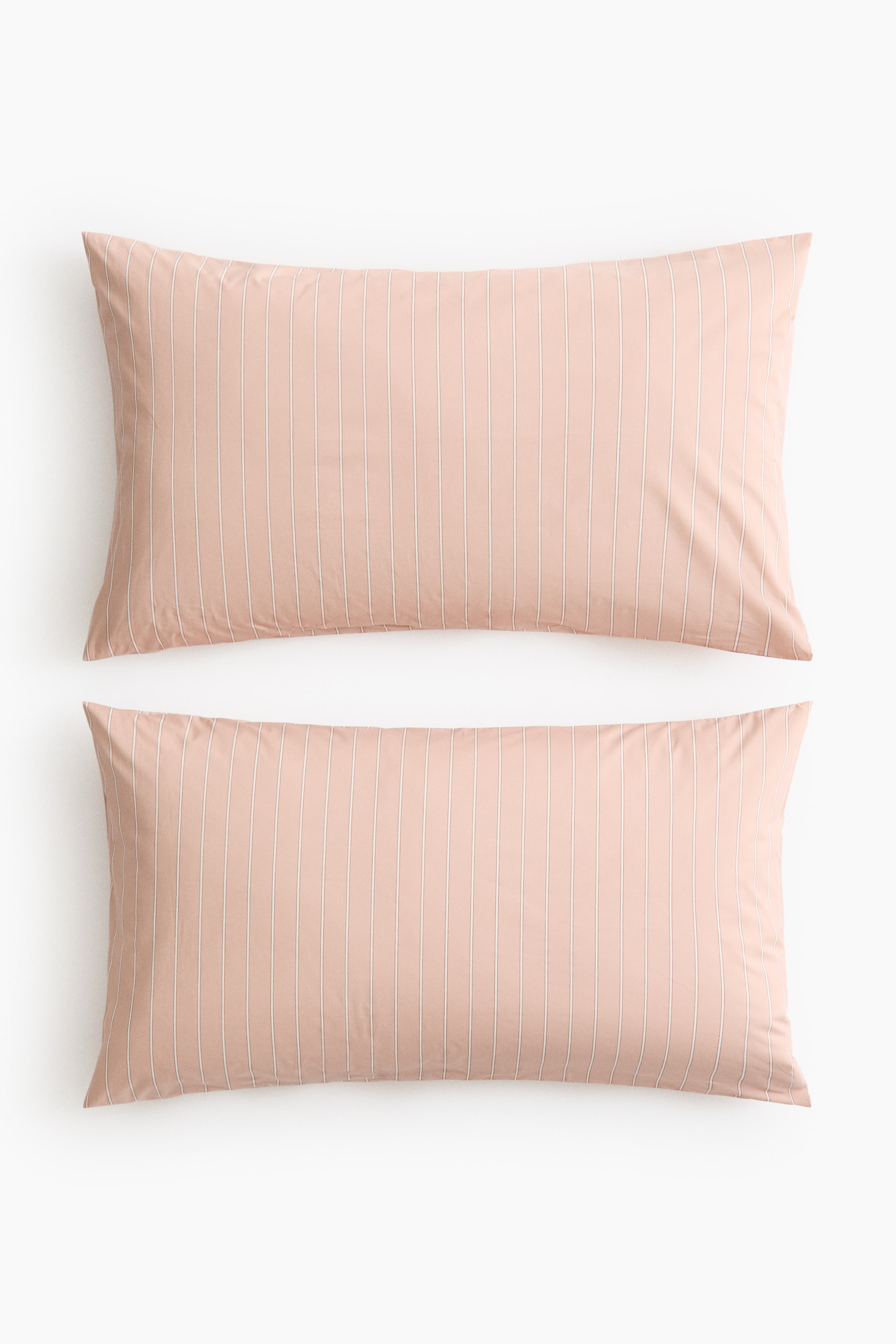 View larger image: Pillowcases showcase a soft cotton weave in a light pink hue, patterned with thin white vertical stripes, and feature an envelope opening.