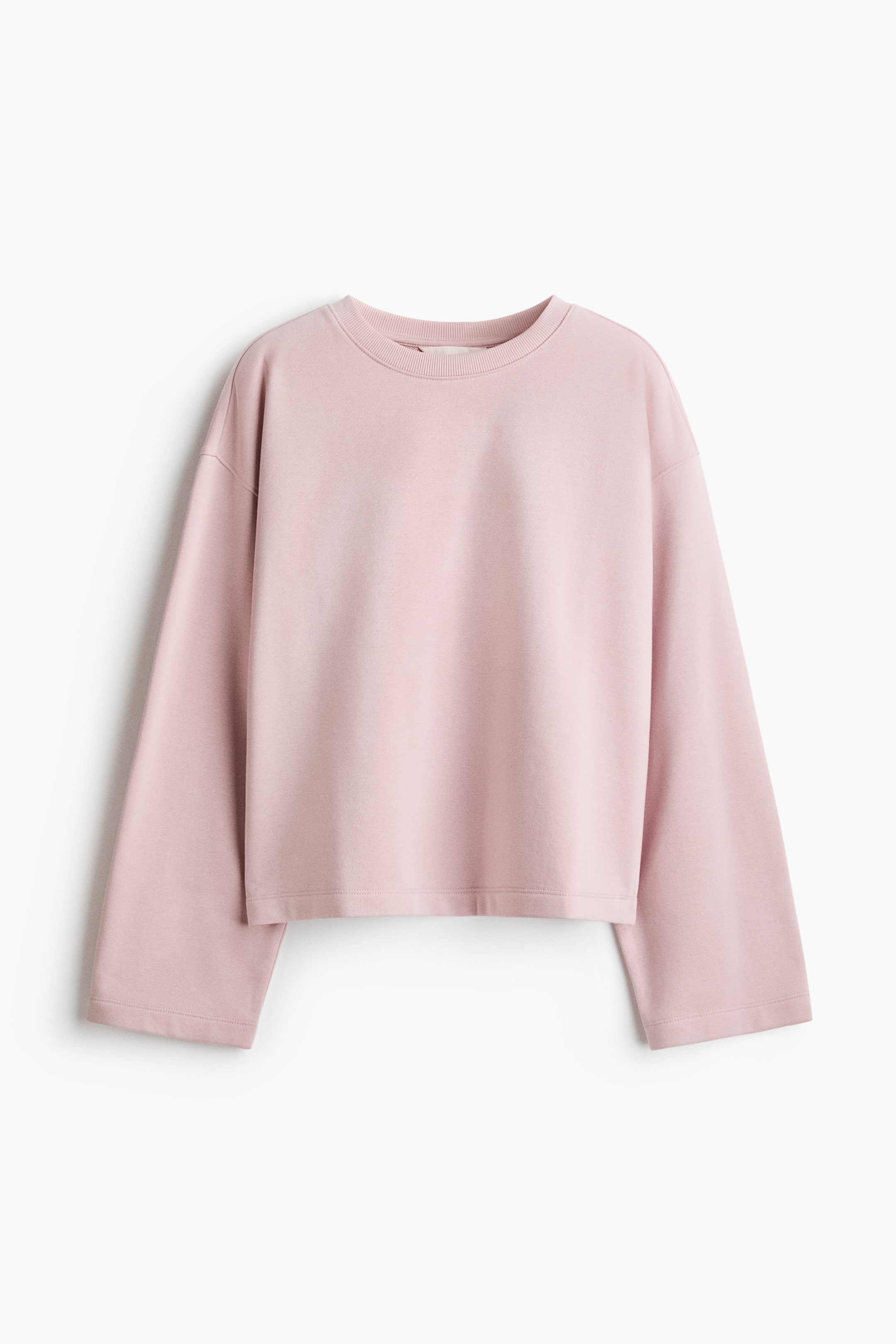 View larger image: A light pink, relaxed-fit sweater is shown from the front, featuring a round, rib-trimmed neckline and dropped shoulders. The long, wide-cut sleeves and straight hem hang loosely to highlight its comfortable, casual design.