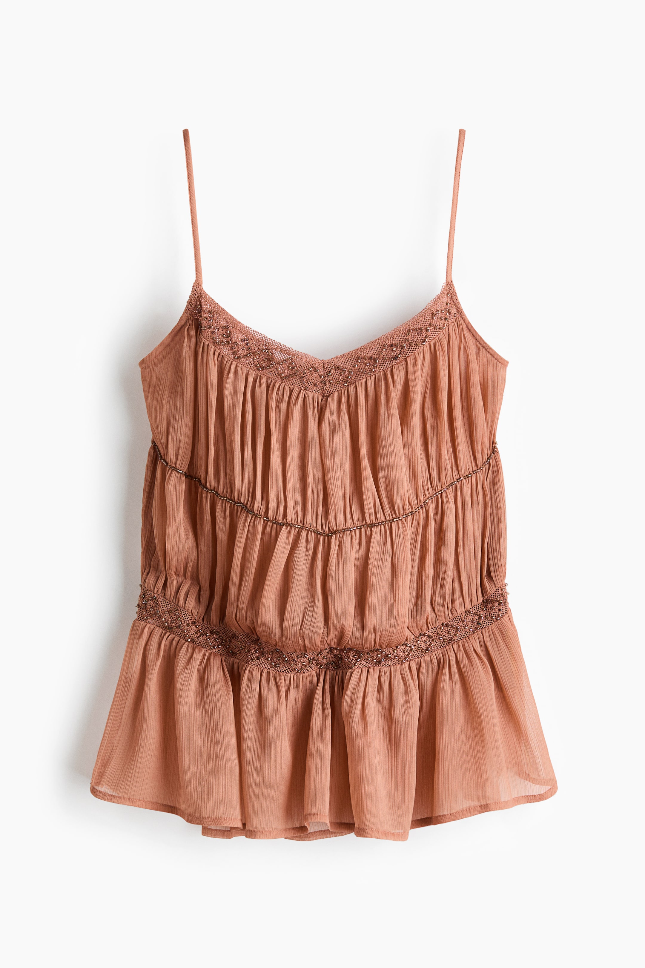 Grotere afbeelding bekijken: Een roestkleurige camisole toont zijn voorkant, met dunne spaghettibandjes en een V-hals. Het lijfje vormt drie geplooide lagen, met kantafwerking langs de halslijn en tussen elke laag.