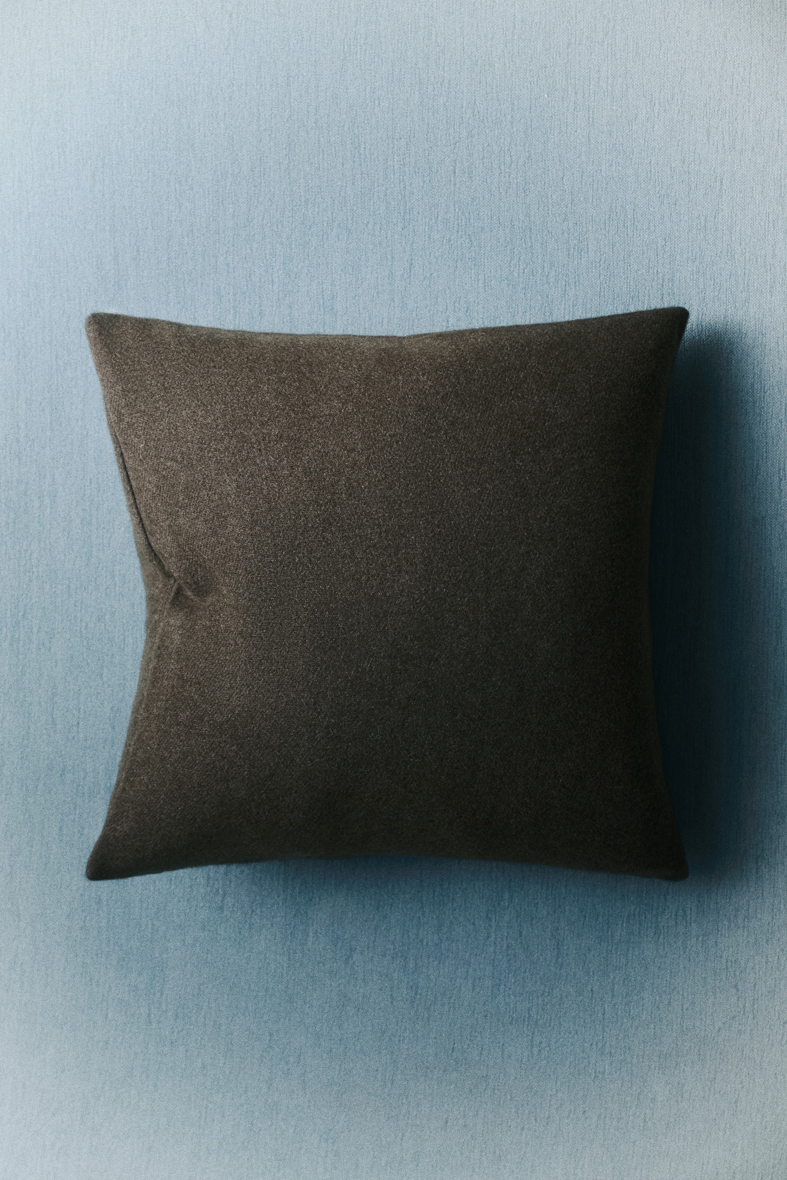 A rectangular cushion showcases a dark heathered grey-brown shade and a soft, consistent texture when viewed from a front-facing angle. - 1
