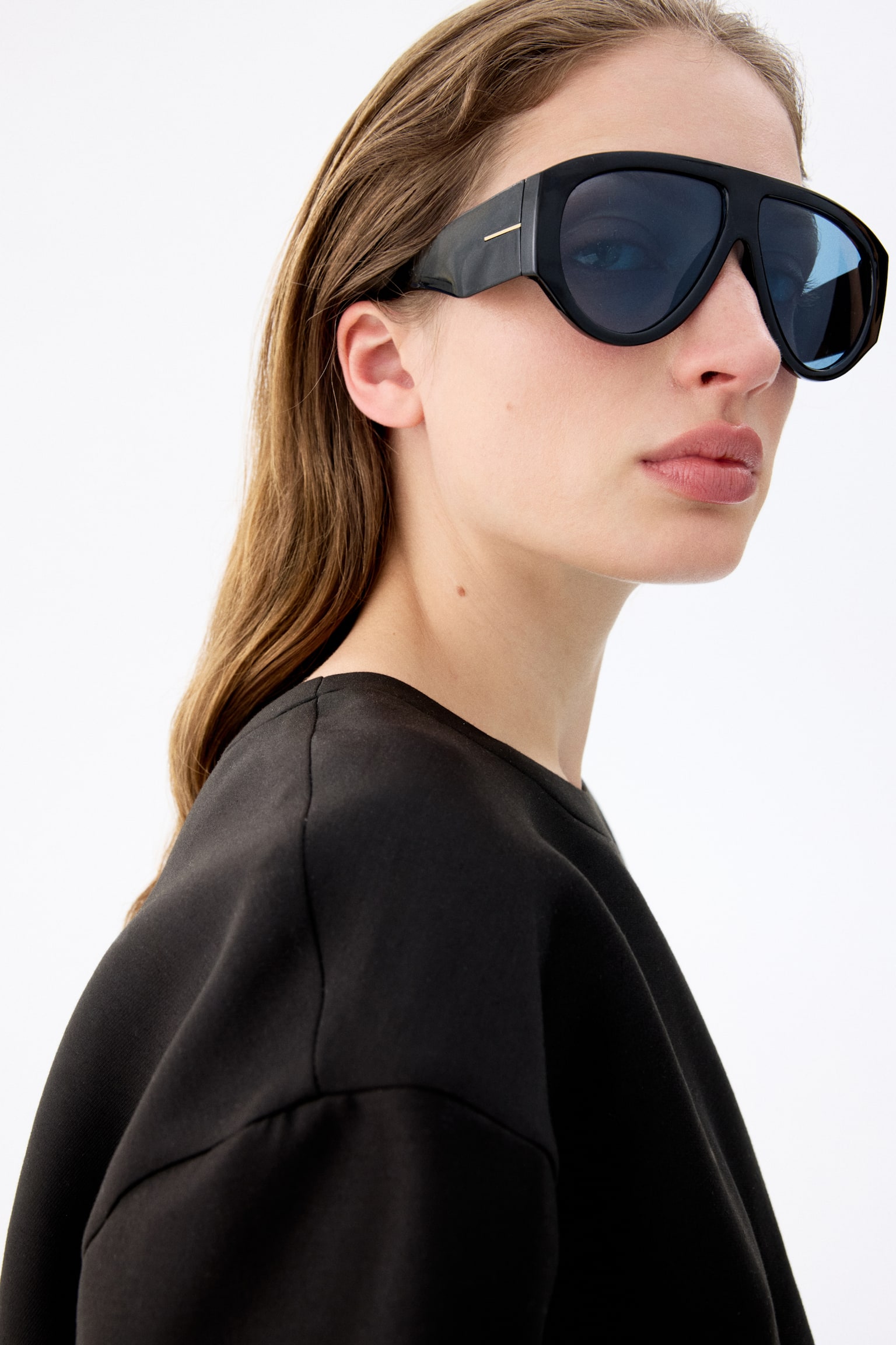 Ochelari de soare negri, stil aviator, sunt orientați frontal, având o ramă din plastic cu brațe laterale late. Ochelarii de soare sunt echipați cu lentile întunecate, polarizate, cu protecție UV. - 1
