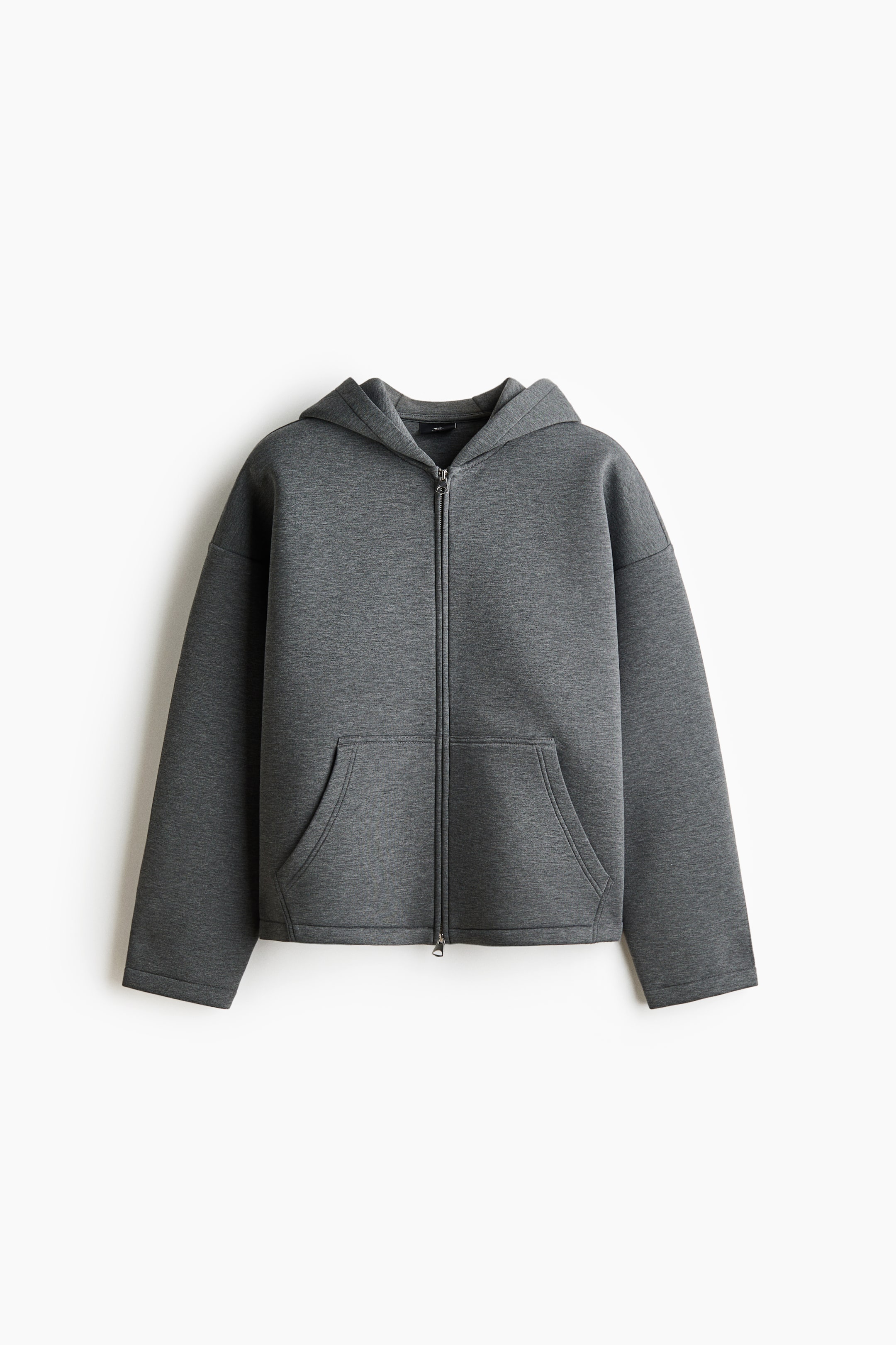 View larger image: A dark gray zip-front hoodie in scuba fabric is shown from the front, featuring a lined hood, a two-way front zipper, and dropped shoulders. It has open front pockets and an oversized fit, creating a baggy, extra-loose silhouette.