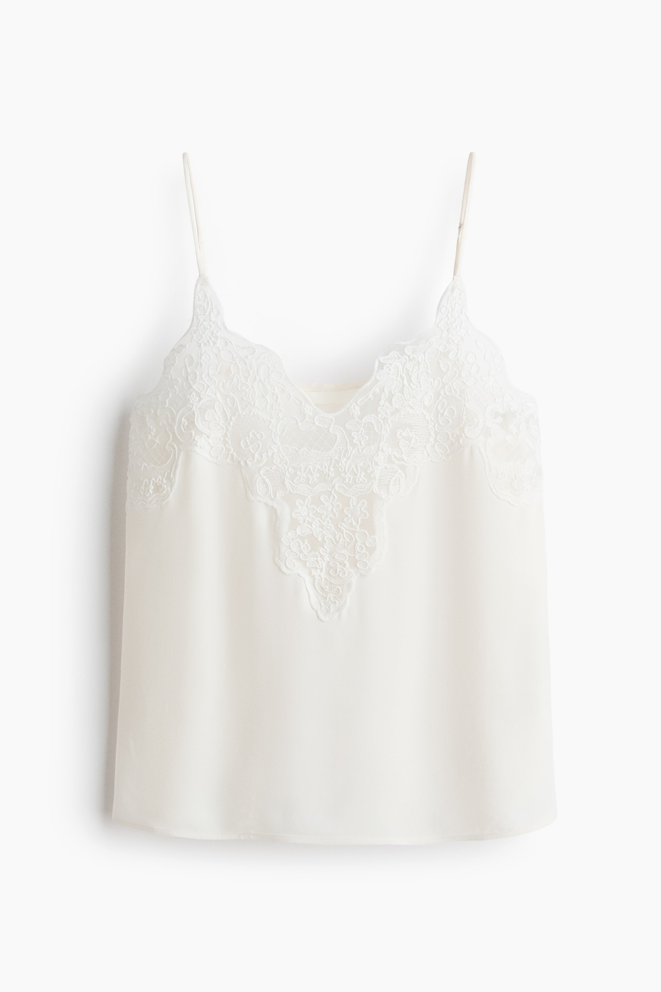 View larger image: A cream camisole is showcased front-facing, highlighting slender spaghetti straps, a sleek body, and a V-neckline adorned with delicate, scalloped lace.