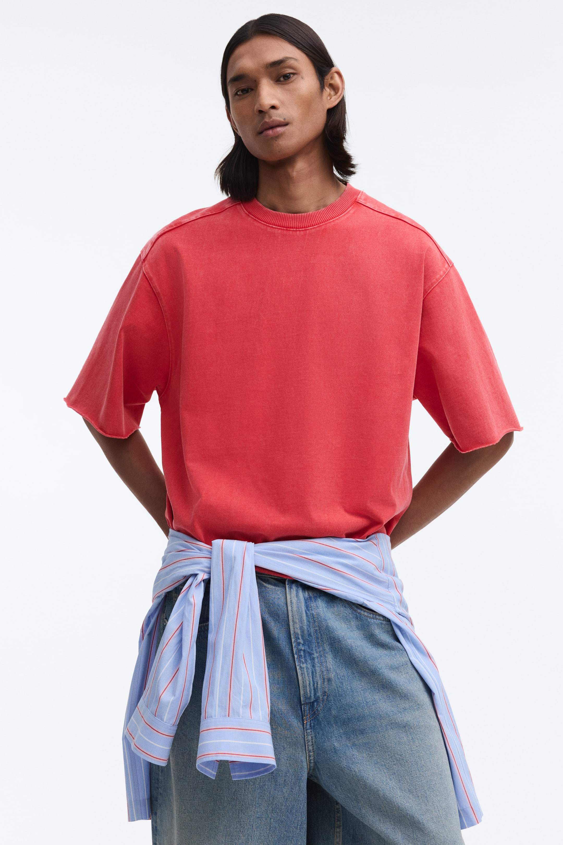 View larger image: A washed red t-shirt featuring a ribbed crew neck and short sleeves with raw edges, showcasing a relaxed fit from the front.