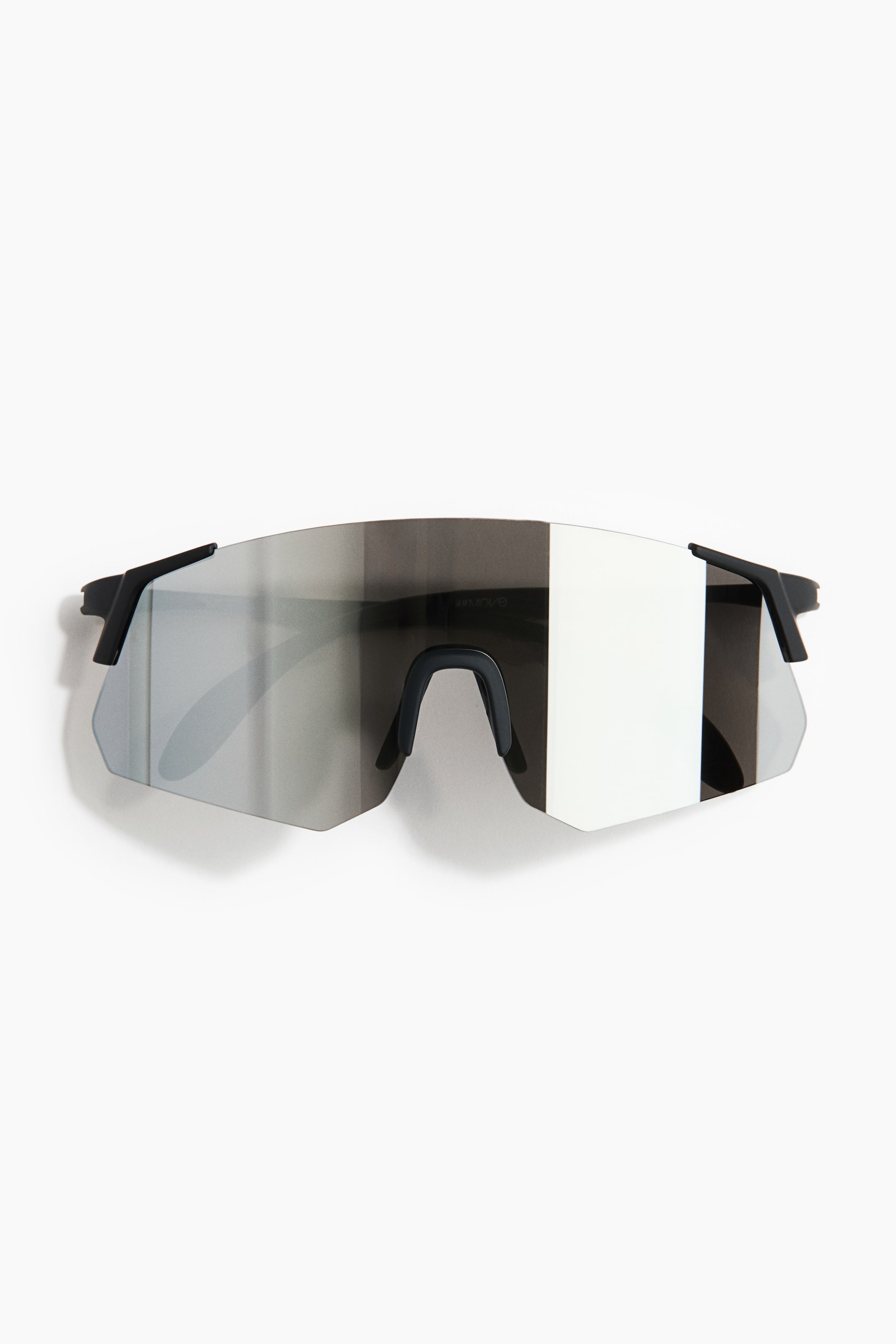 View larger image: The sunglasses feature a large, single shield lens with a mirrored silver finish, viewed from the front. Black temple arms extend from the sides, and a black nose pad is centrally positioned.