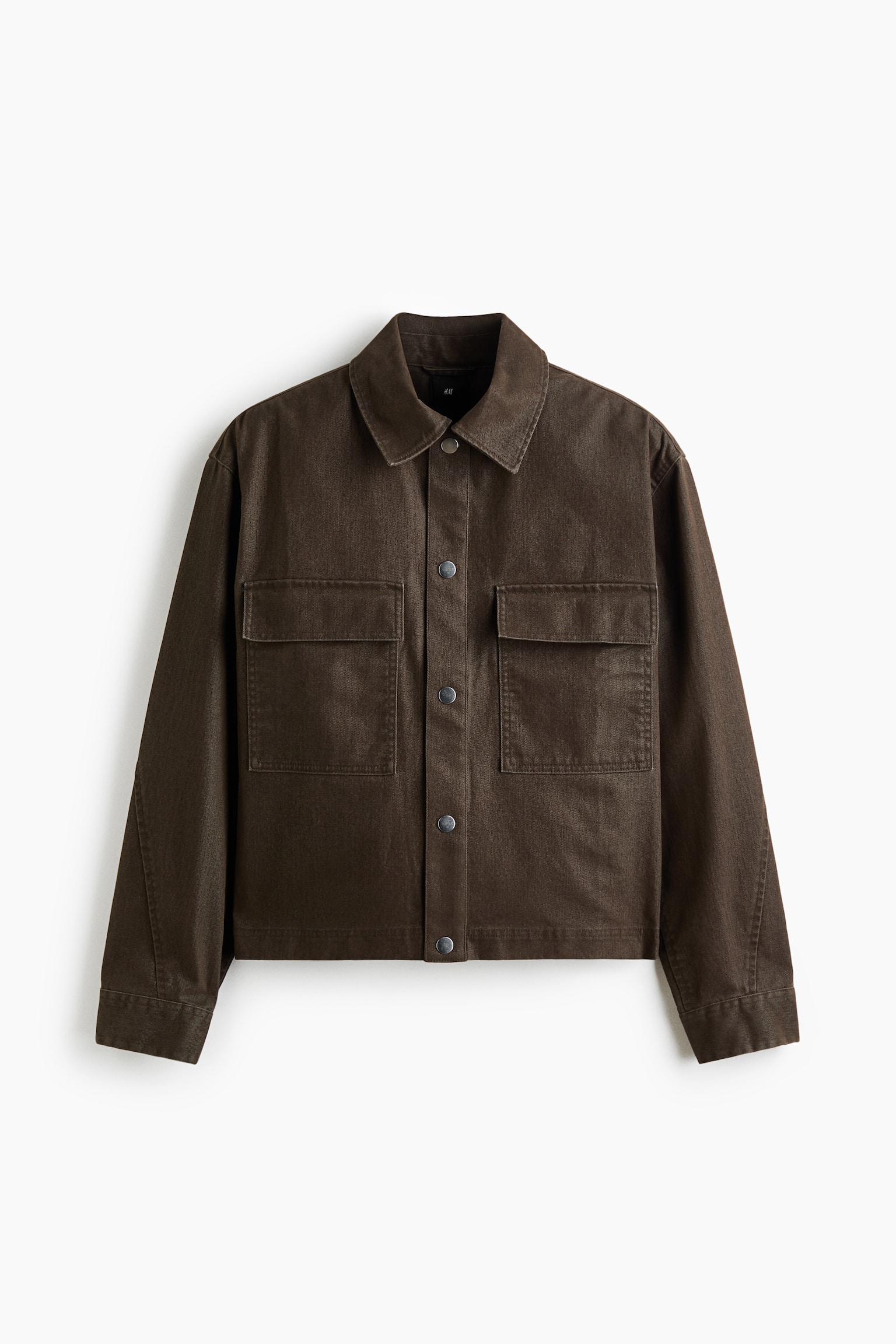 A dark brown jacket is shown from the front, featuring a spread collar, front snap-button closure, and long sleeves. It has two large chest patch pockets with flaps and a boxy, cropped fit.