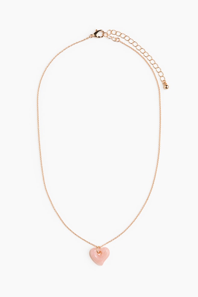 A metal chain necklace showcases a heart-shaped pendant in glossy pink plastic. It features an adjustable length with a trigger clasp. - 1