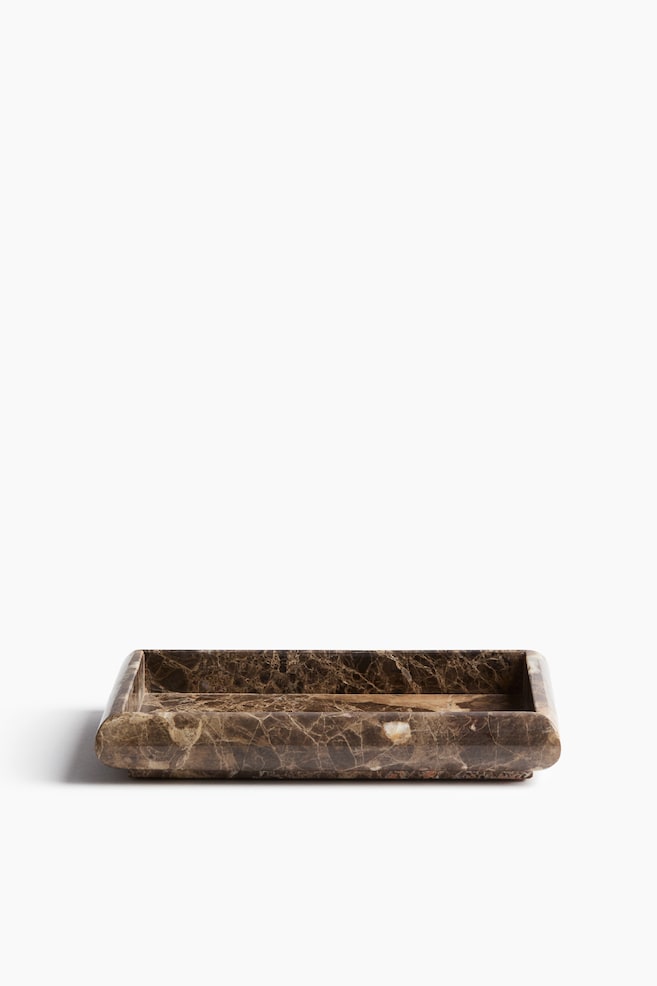 A rectangular marble tray is being displayed, featuring a dark brown colour with intricate white and lighter brown veining. It forms a shallow, rectangular basin and presents subtly rounded exterior corners. - 1