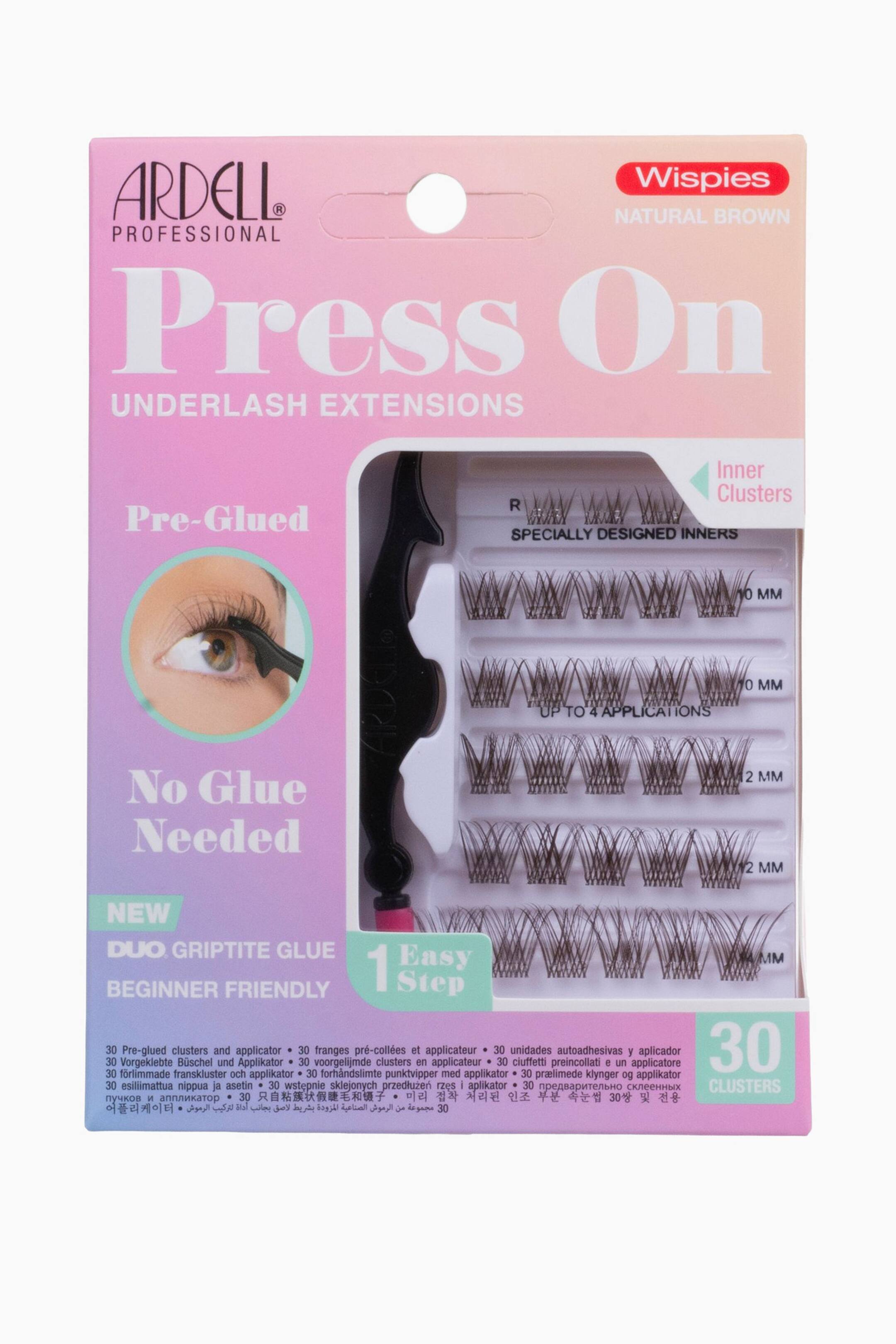 Se større billede: Ardell Press On Wispies Natural Brown underlash extensions-sættet vises i en kortemballage med pink og ferskenfarvet gradient og et klart plastikvindue. Inde bag vinduet ligger tredive forlimede brune vippeklynger i længder fra 10 mm til 14 mm placeret i vandrette rækker ved siden af et sort påføringsværktøj.
