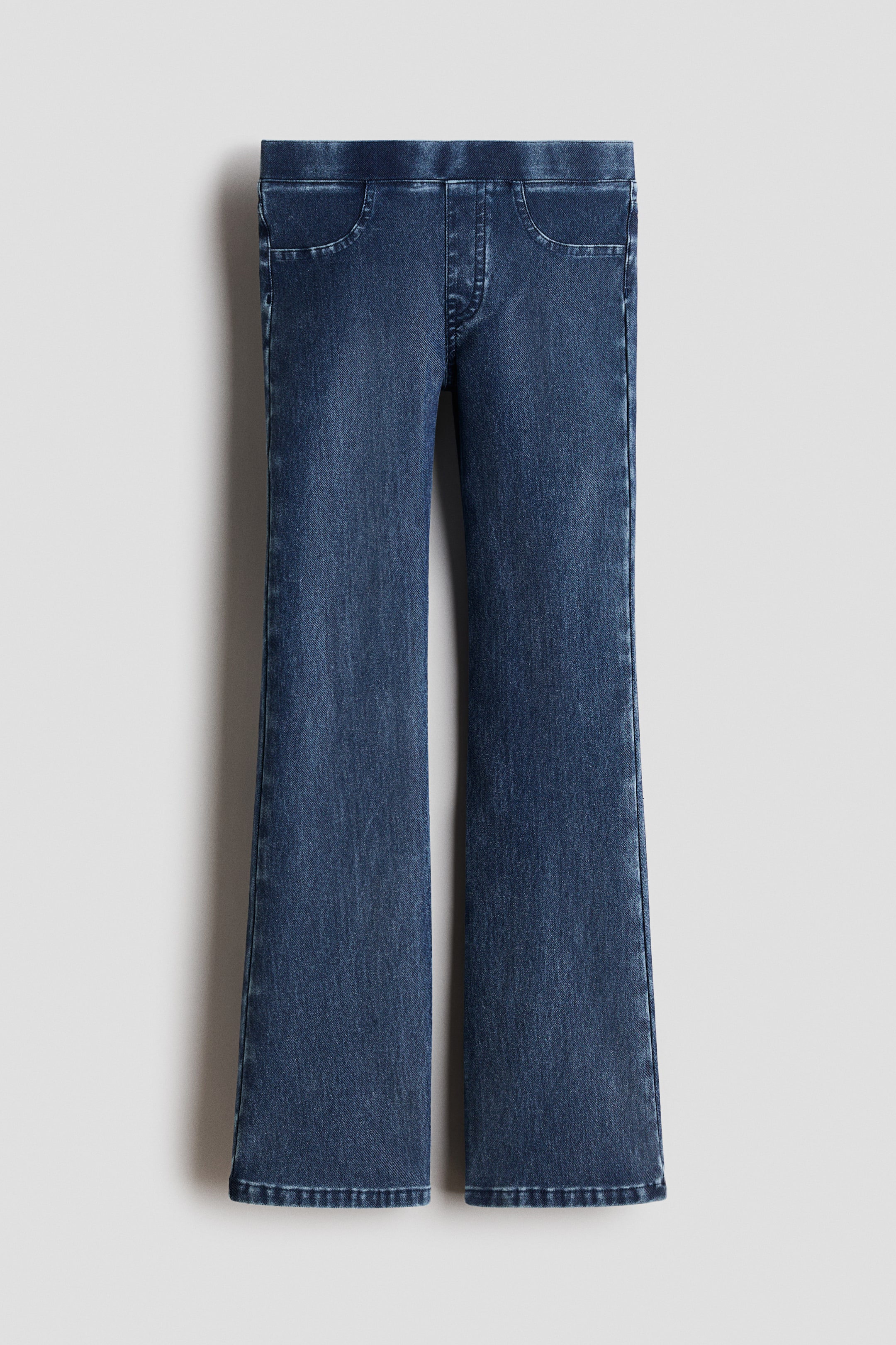 Größeres Bild ansehen: Jeggings präsentieren sich von vorne und zeigen ein schweres, denim-aussehendes Jersey. Sie verfügen über einen elastischen Bund, einen falschen Hosenschlitz, dekorative Vordertaschen und ausgestellte Beine.