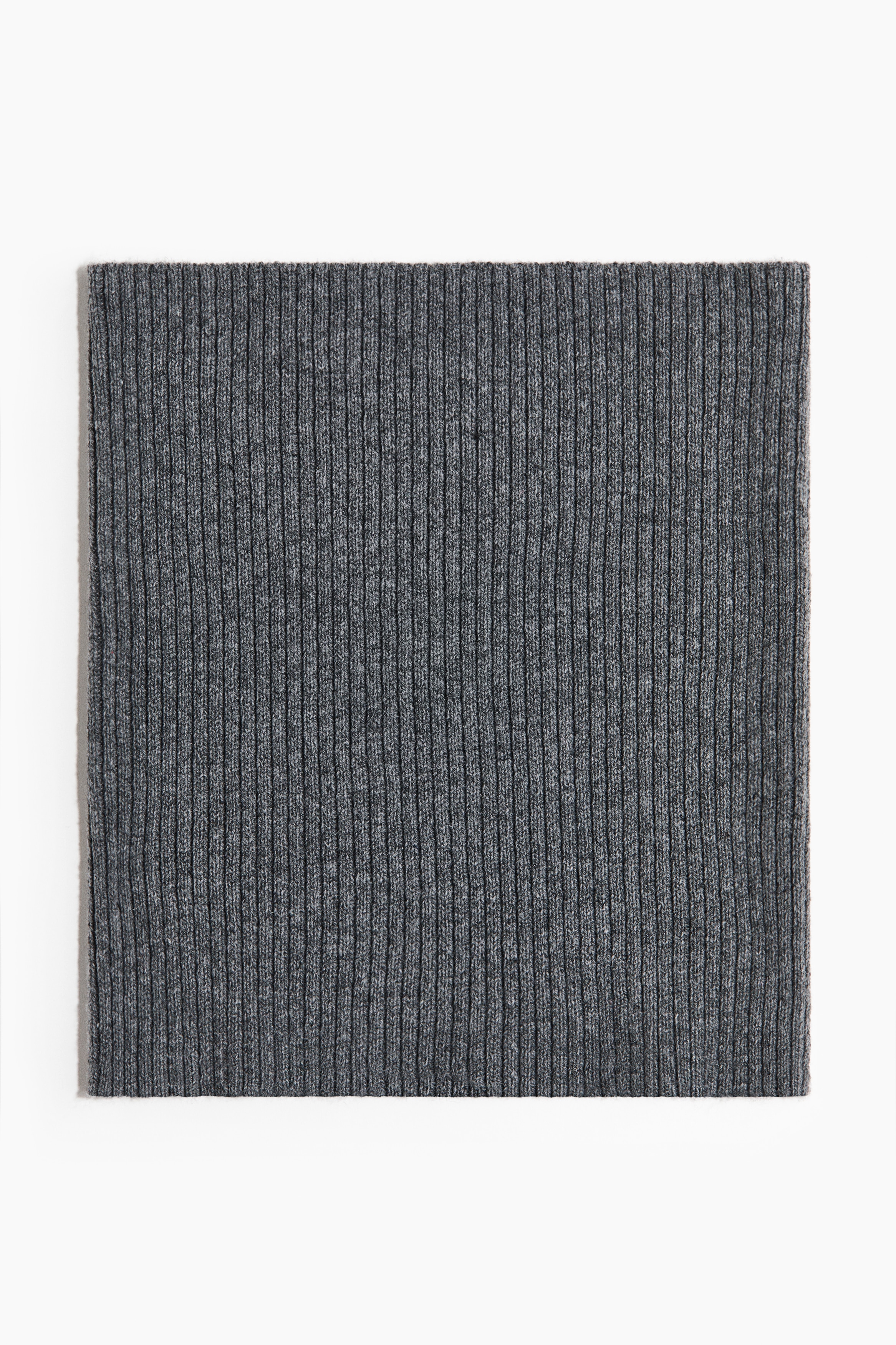 Una bufanda tubular de punto canalÃ© en un suave color azul grisÃ¡ceo estÃ¡ puesta alrededor del cuello de la modelo. Va superpuesta por debajo de un cÃ¡rdigan de punto gris con textura afelpada.