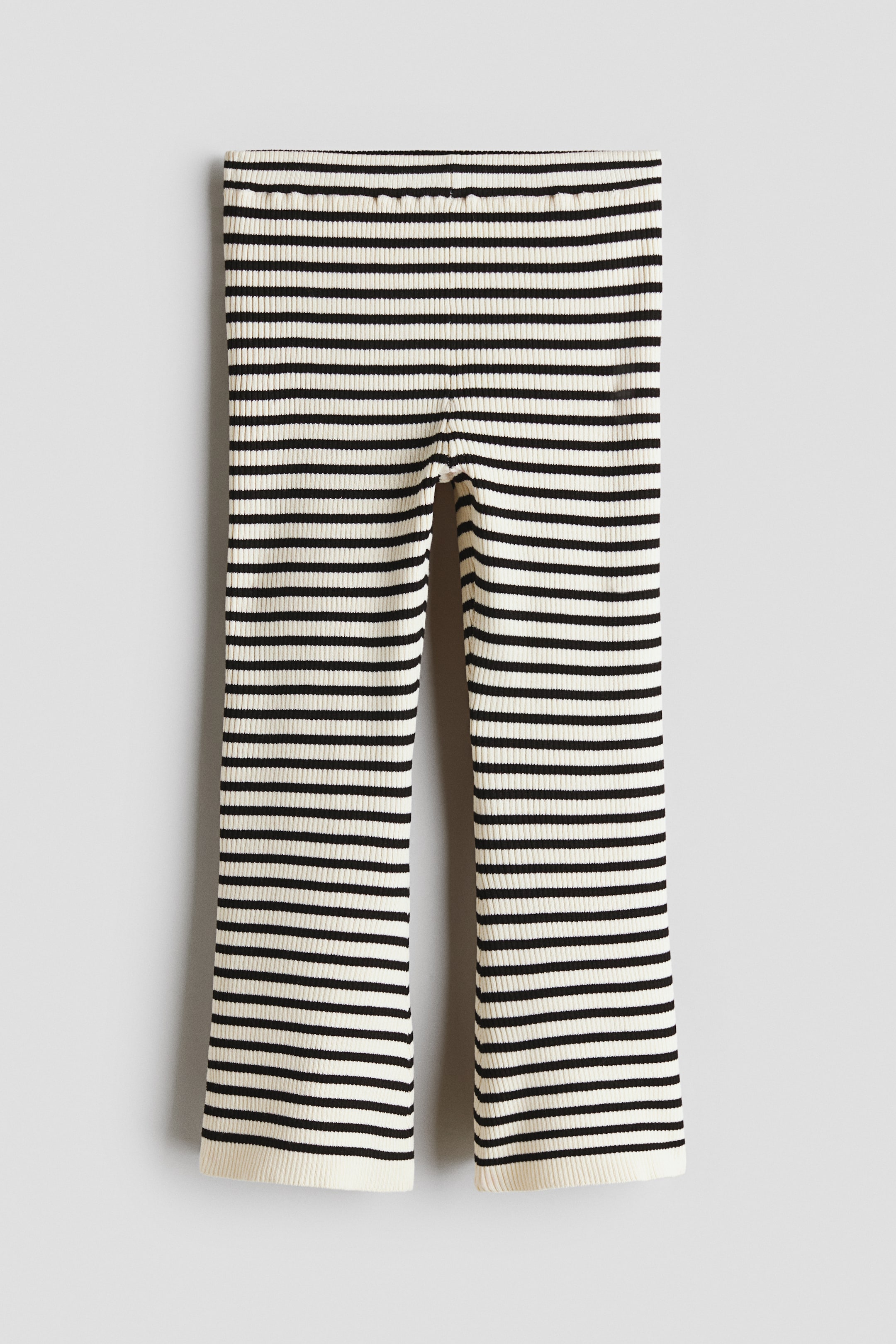 View larger image: The pants showcase a ribbed knit texture, featuring alternating black and cream horizontal stripes. The elasticated waistband and straight legs are prominently visible from the front.