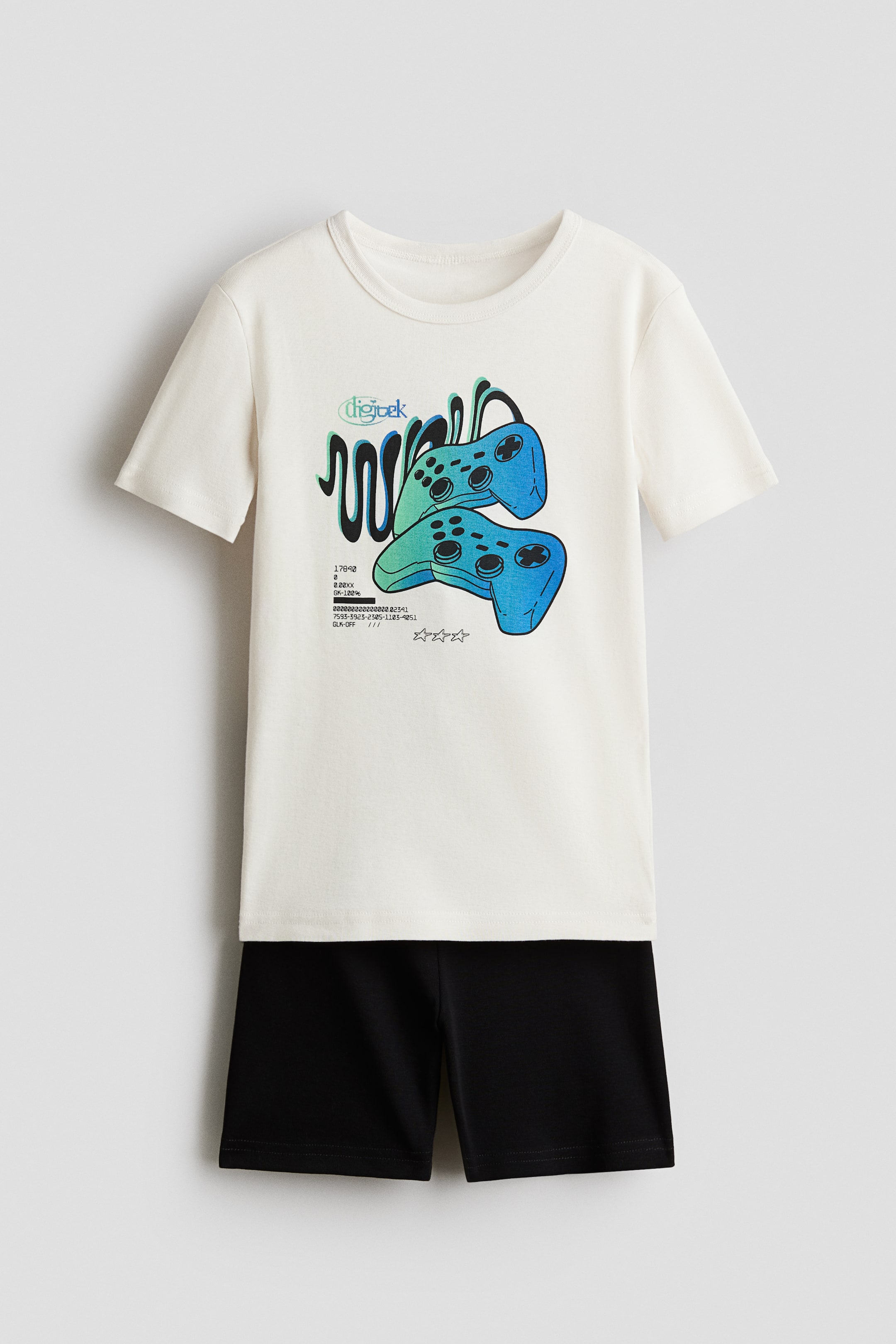 Voir une image plus grande: Pyjamas, présentés de face, comprennent un t-shirt écru et un short noir. Le t-shirt présente un imprimé graphique de deux manettes de jeu en dégradé bleu et vert sur le devant. Le short noir est conçu avec une taille élastiquée.